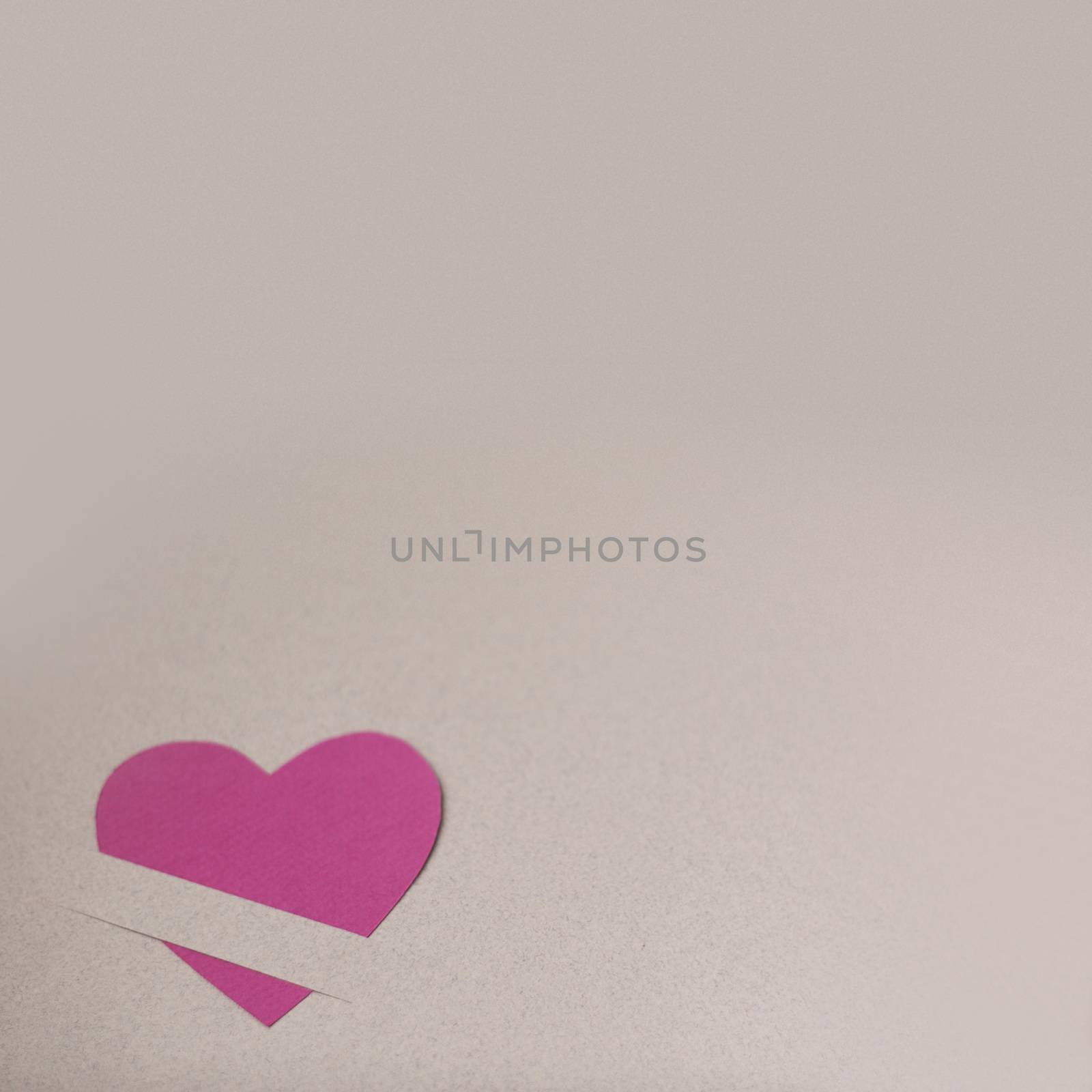 Pink paper hearts on light paper textured background