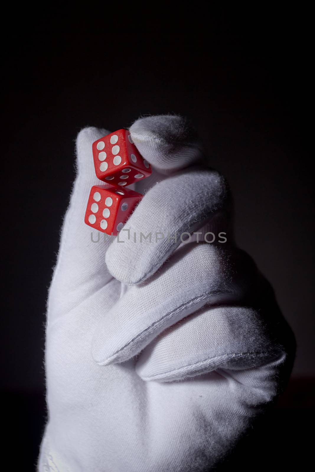 Hand in a white glove with red dice