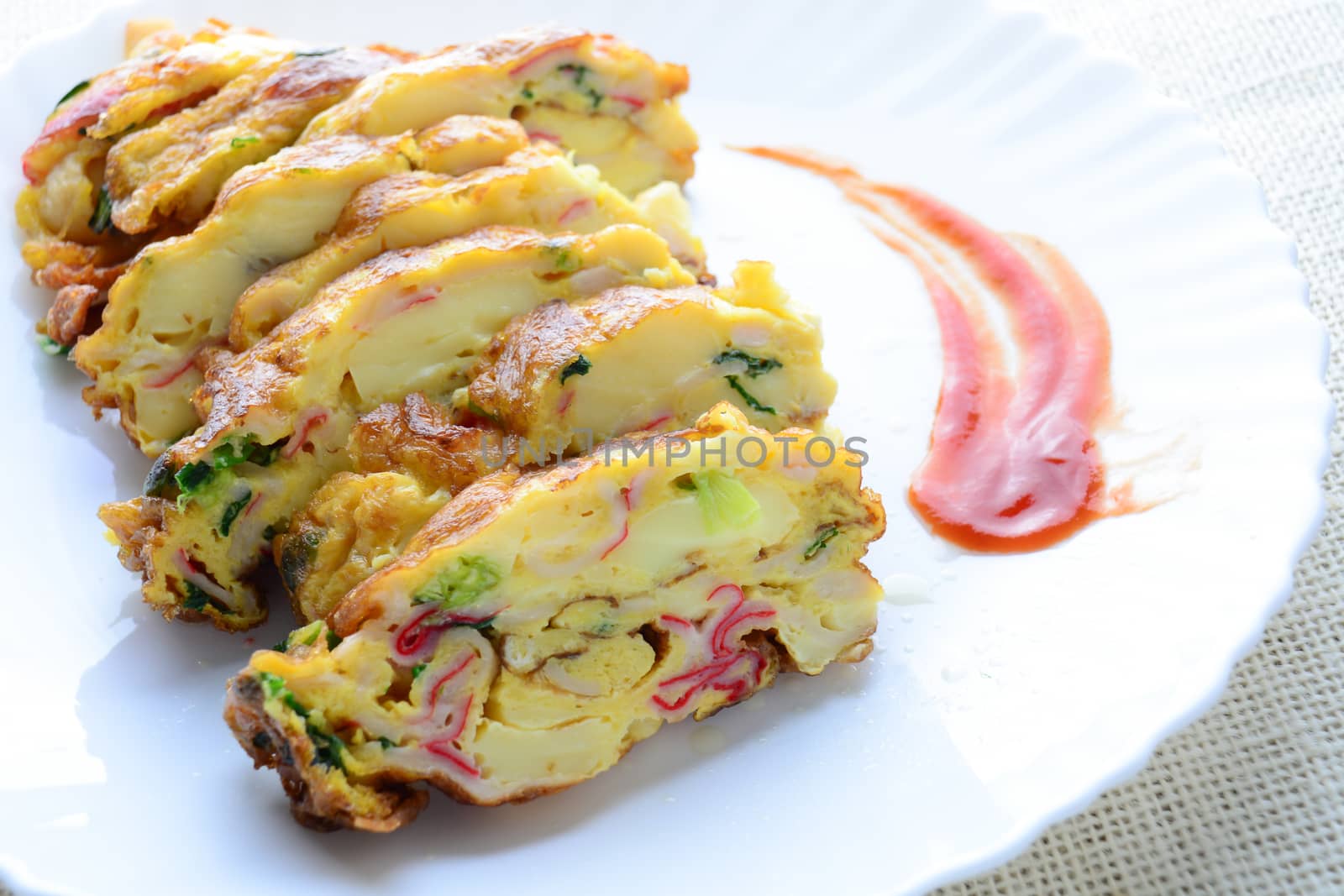 Sliced omelette with soft tofu, crab stick and spring onion with rice on dish