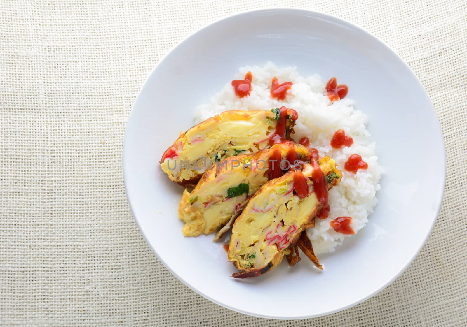 Sliced omelette with soft tofu, crab stick and spring onion with rice on dish