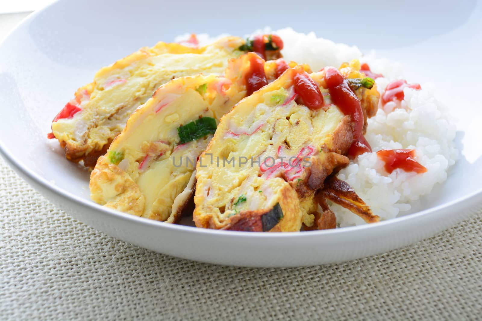 Sliced omelette with soft tofu, crab stick and spring onion with rice on dish