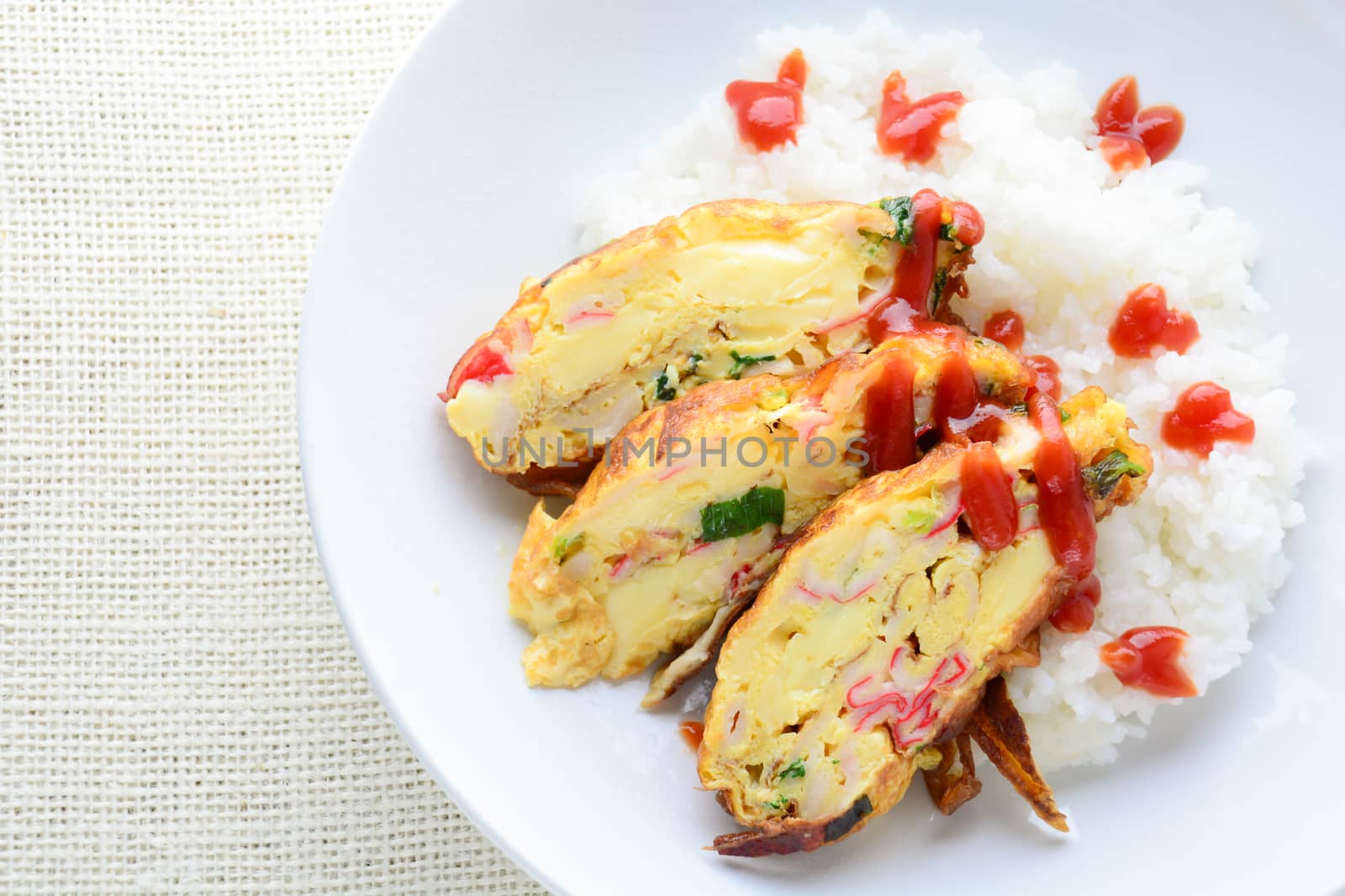 Sliced omelette with soft tofu, crab stick and spring onion with rice on dish