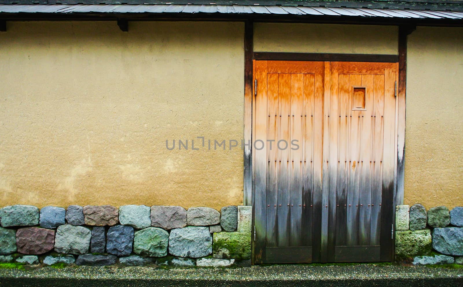 Closed wooden door with the stones wall.