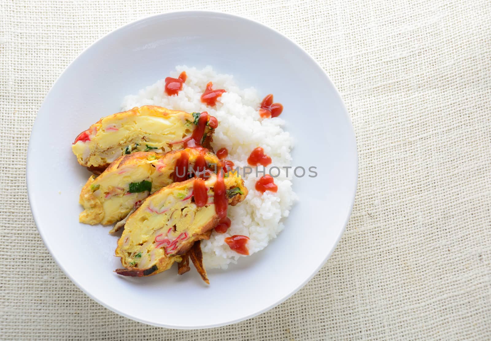 Sliced omelette with soft tofu, crab stick and spring onion with rice on dish