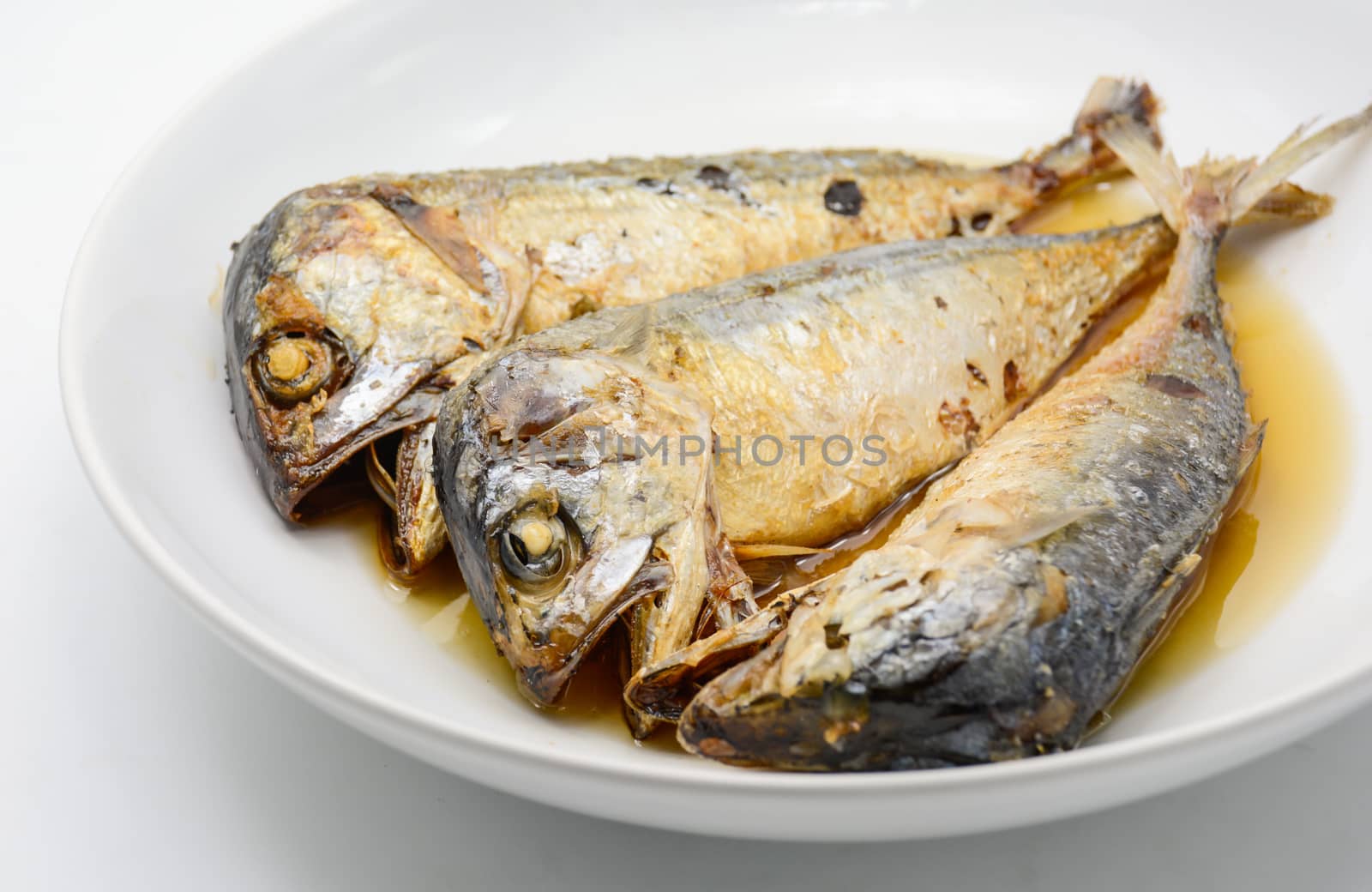 Fried mackerel on white plate. Deep fried fish