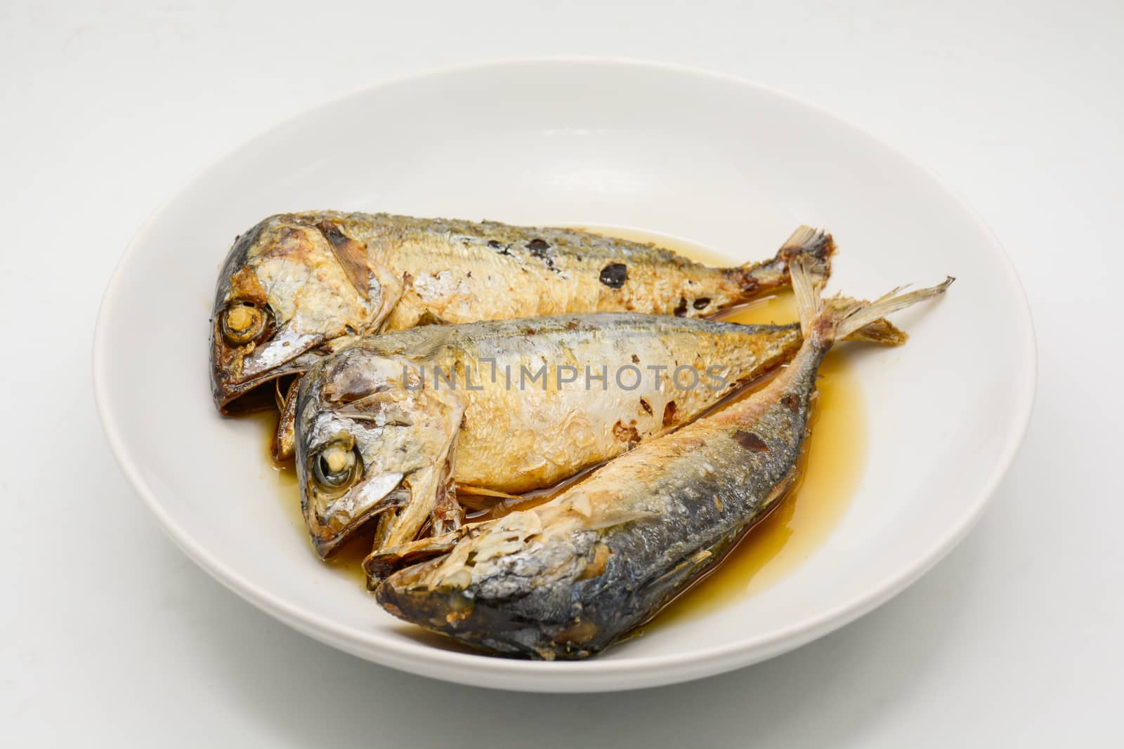 Fried mackerel on white plate. Deep fried fish by yuiyuize