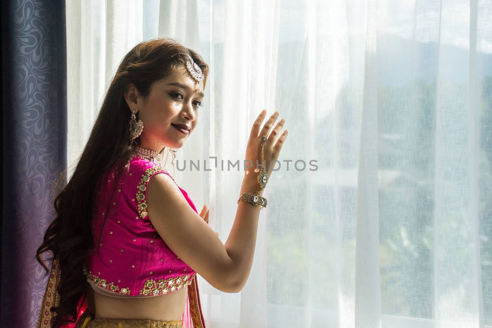 Pink and Yellow Indian Costume Beautiful Girl, face partially covered with saree. Portrait of Traditional woman in sari dress.
