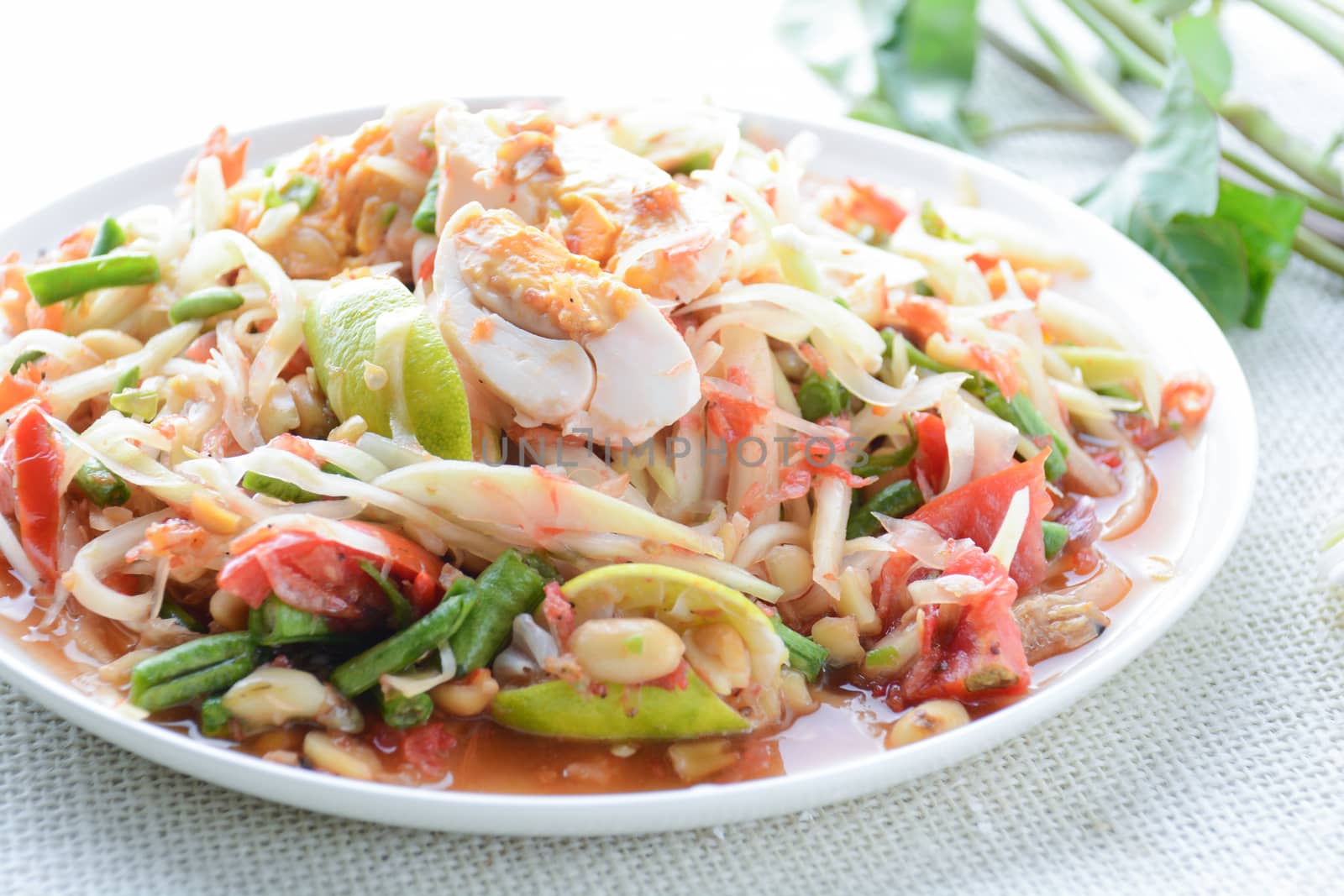 Papaya Salad with Satled Eggs, Pound chilies and garlic then place sliced tomato, eggplant and salted egg. Add fish sauce, lemon, sugar, chopped papaya then mixed all the ingredients together.
