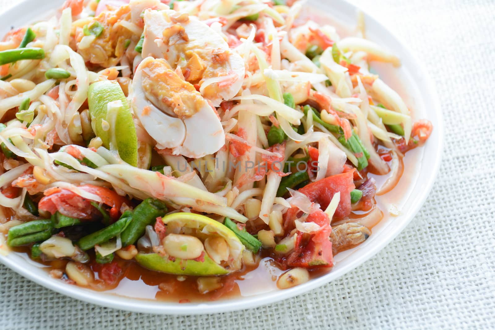 Papaya Salad with Satled Eggs, Pound chilies and garlic then place sliced tomato, eggplant and salted egg. Add fish sauce, lemon, sugar, chopped papaya then mixed all the ingredients together.
