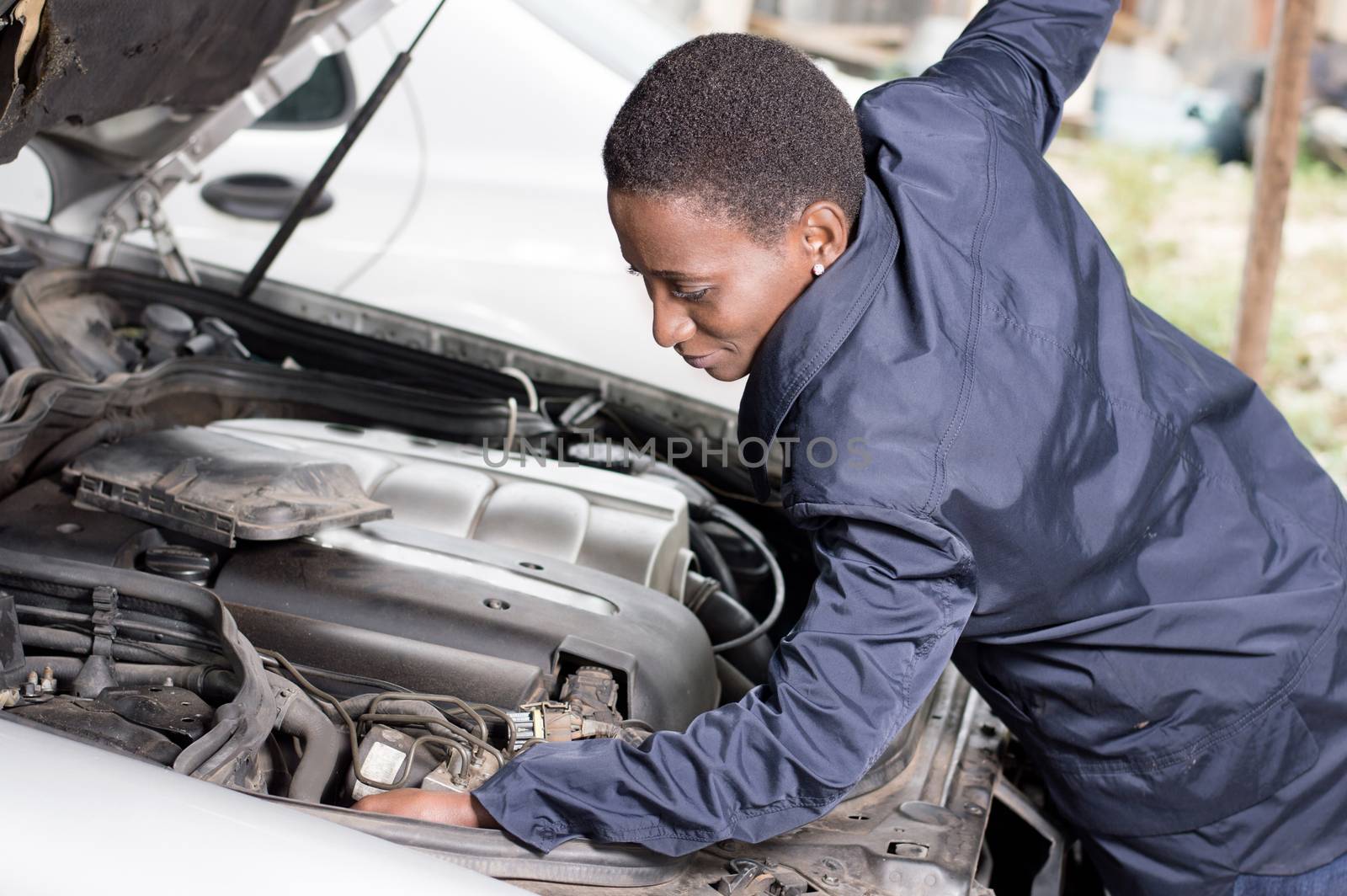 Mechanic repairs the engine of a car in his workshop.