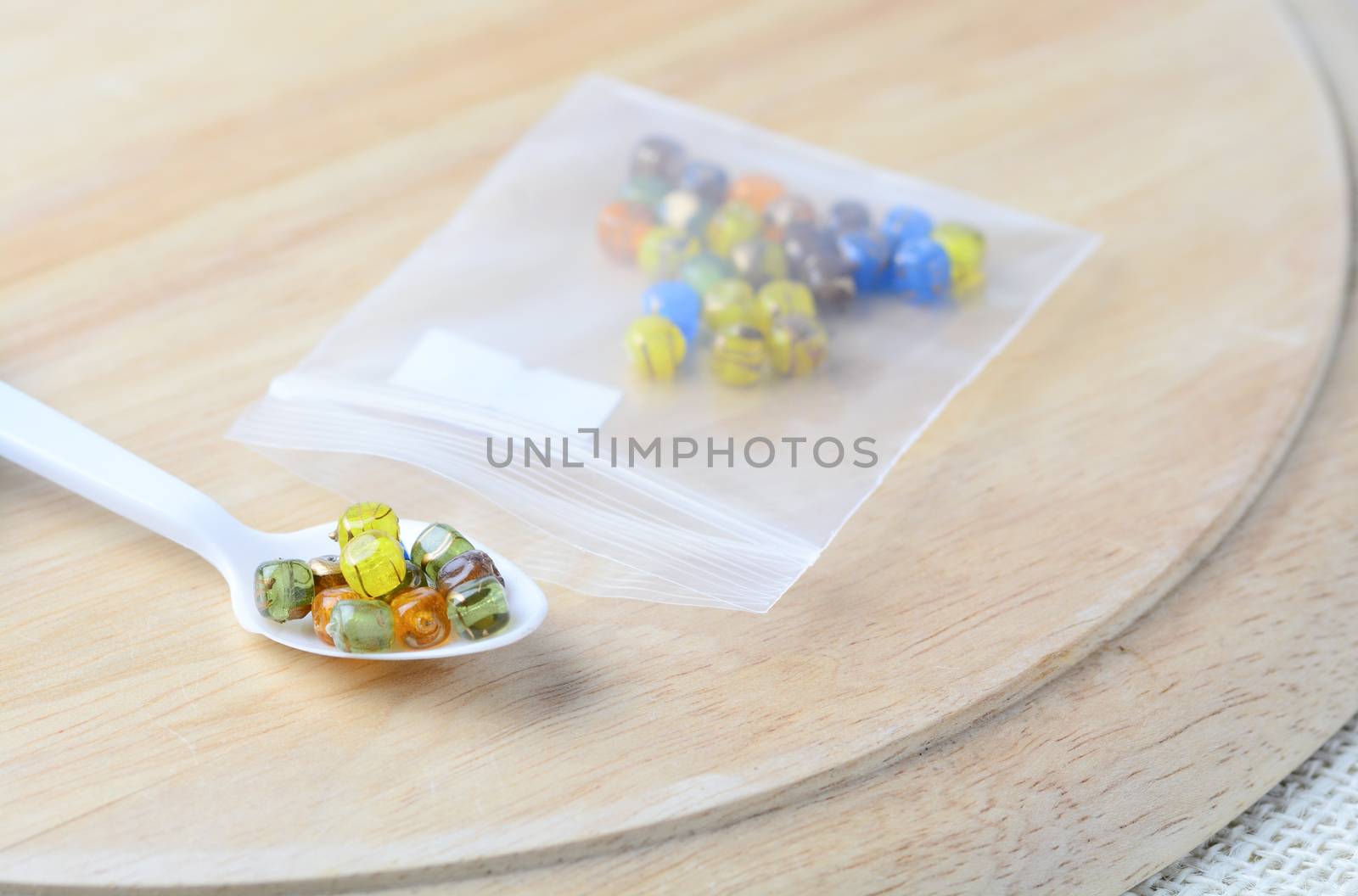 Colorful beads on a wooden surface. Various of shapes and colors to make jewelry
