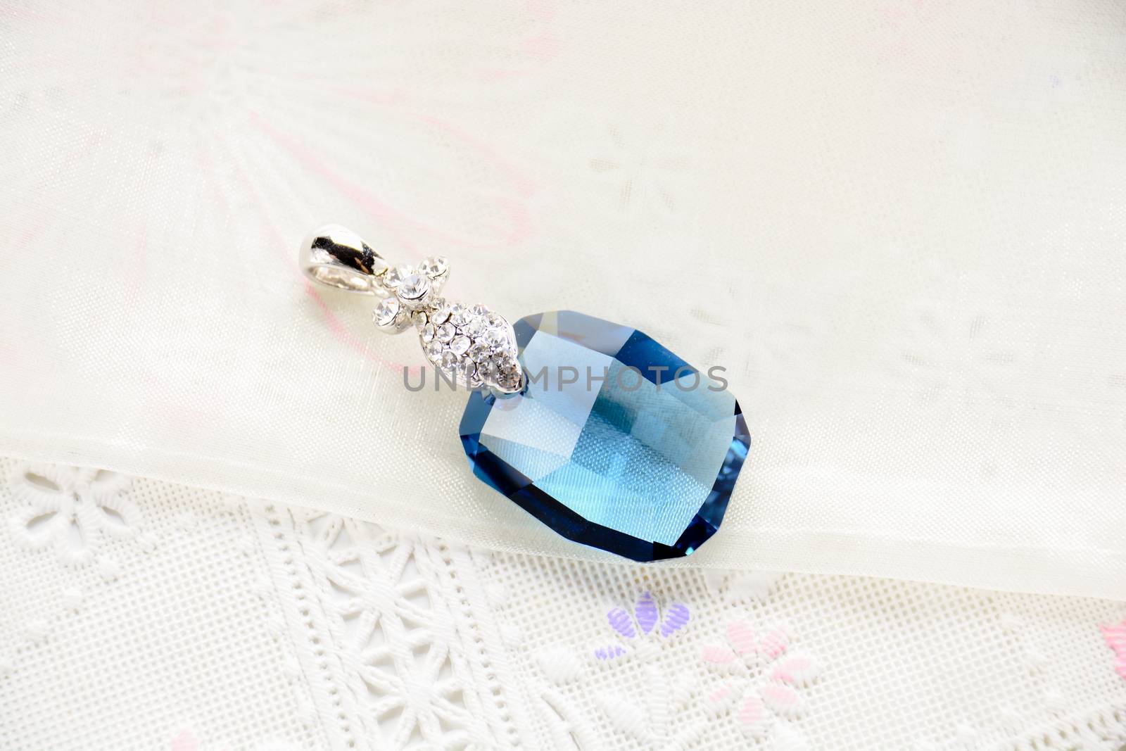 Crystal necklace on white fabric background
