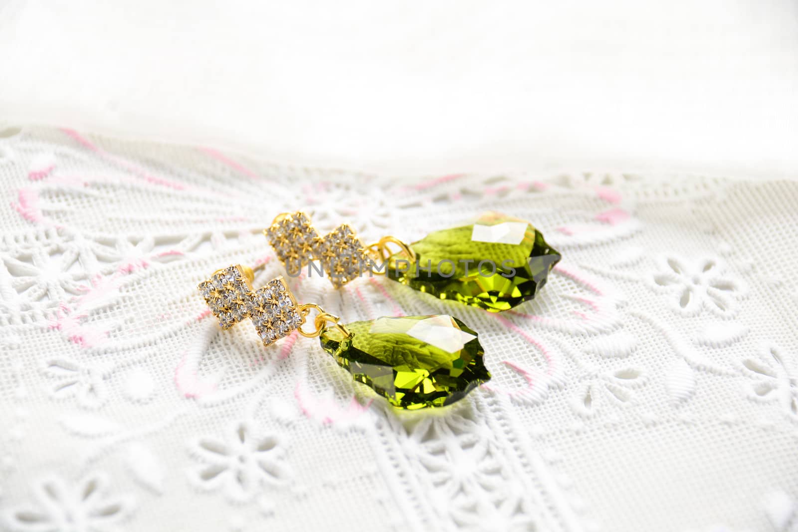 Crystal earrings on white fabric background
