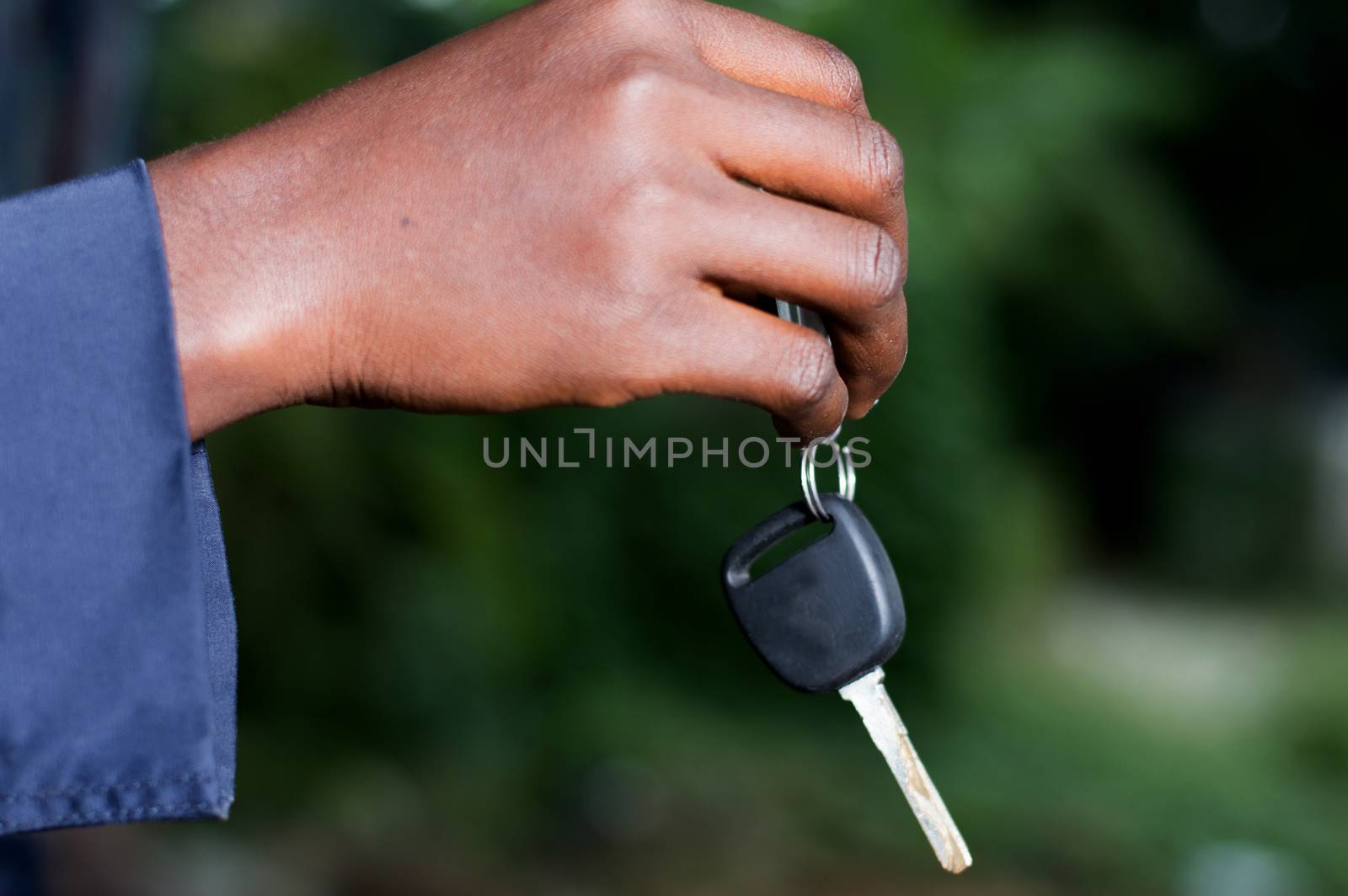 a hand holding a car ignition key outside.
