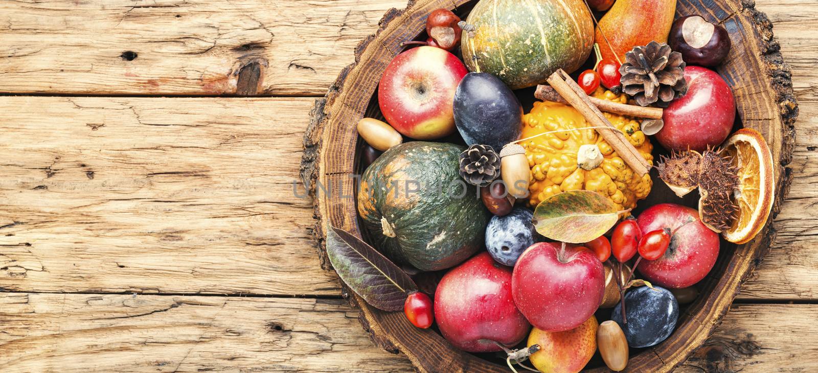 Autumn fruits and pumpkins with fallen leaves.Autumn harvest on wooden table