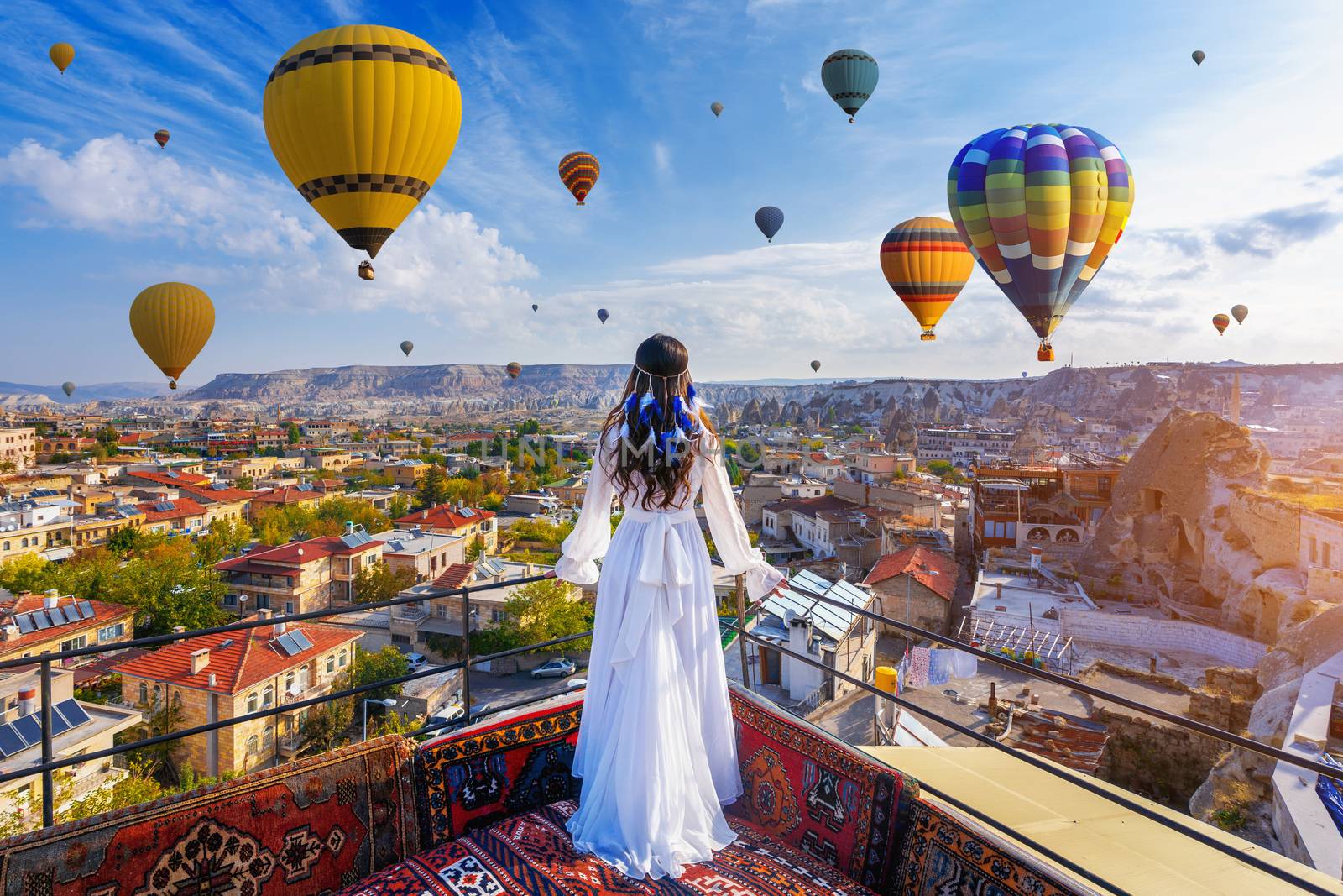 Beautiful girl standing on the hotel and looking to hot air balloons in Cappadocia, Turkey. by gutarphotoghaphy