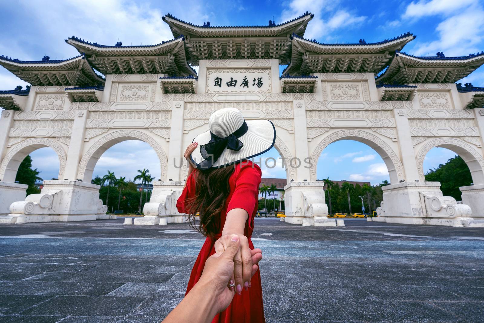 Women tourists holding man's hand and leading him to Chiang Kai Shek Memorial Hall in Taipei, Taiwan. by gutarphotoghaphy