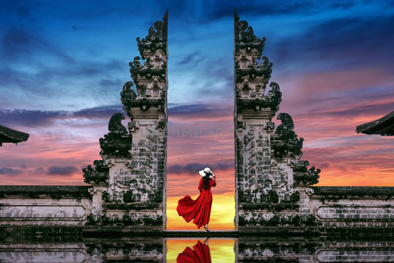Young woman standing in temple gates at Lempuyang Luhur temple in Bali, Indonesia. by gutarphotoghaphy