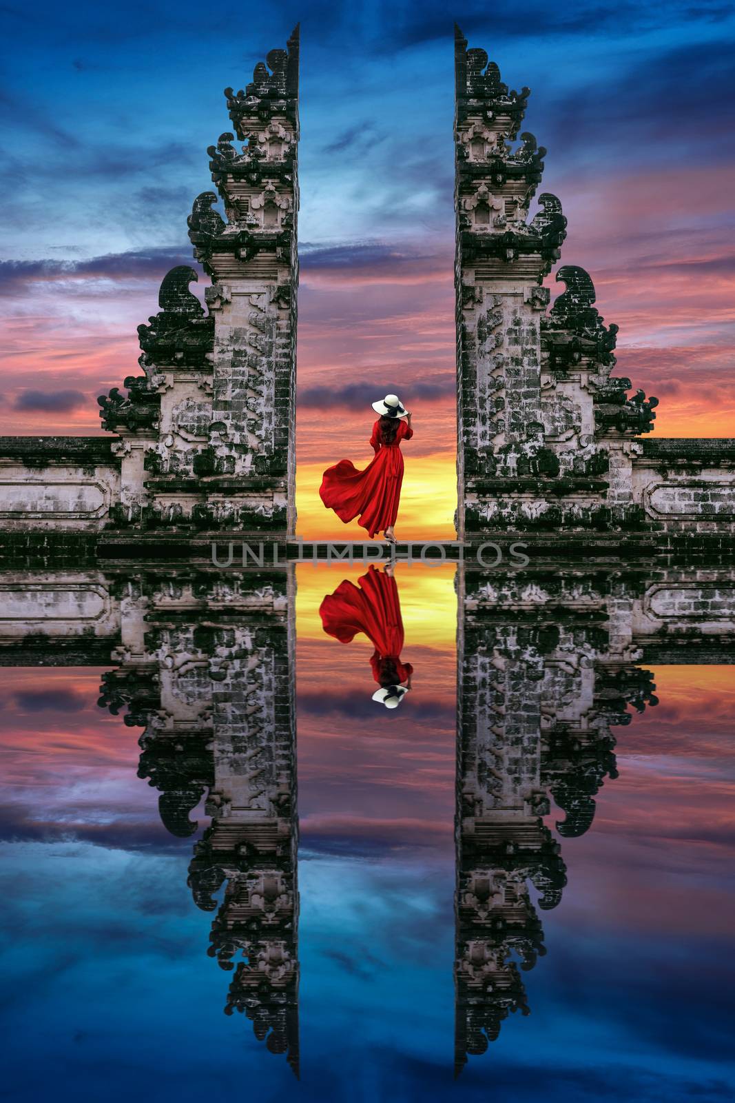 Young woman standing in temple gates at Lempuyang Luhur temple in Bali, Indonesia. by gutarphotoghaphy