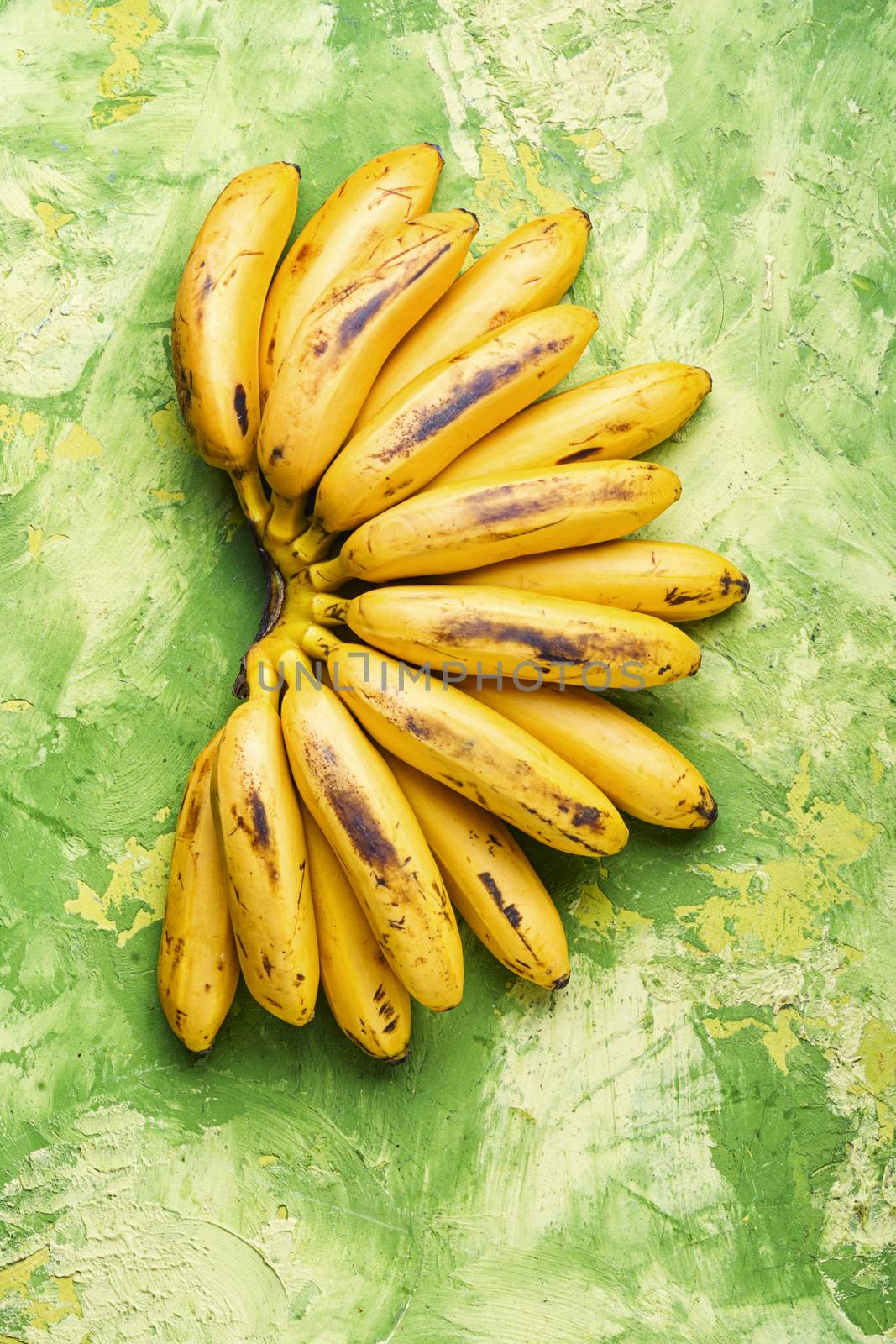 A bunch of ripe bananas on a green background