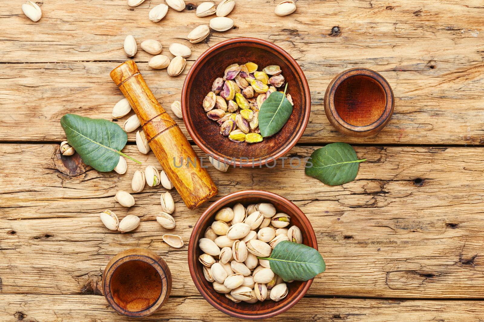 Bowl with pistachios on old wooden table.Nut