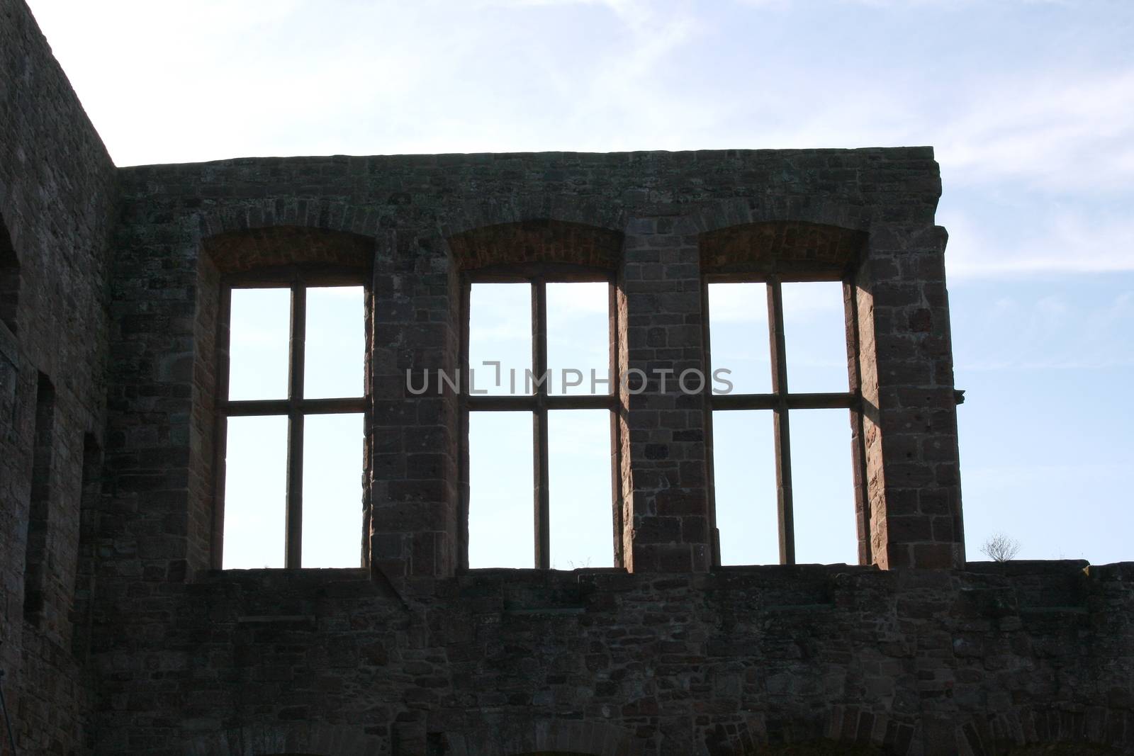 House wall with three windows in the back light