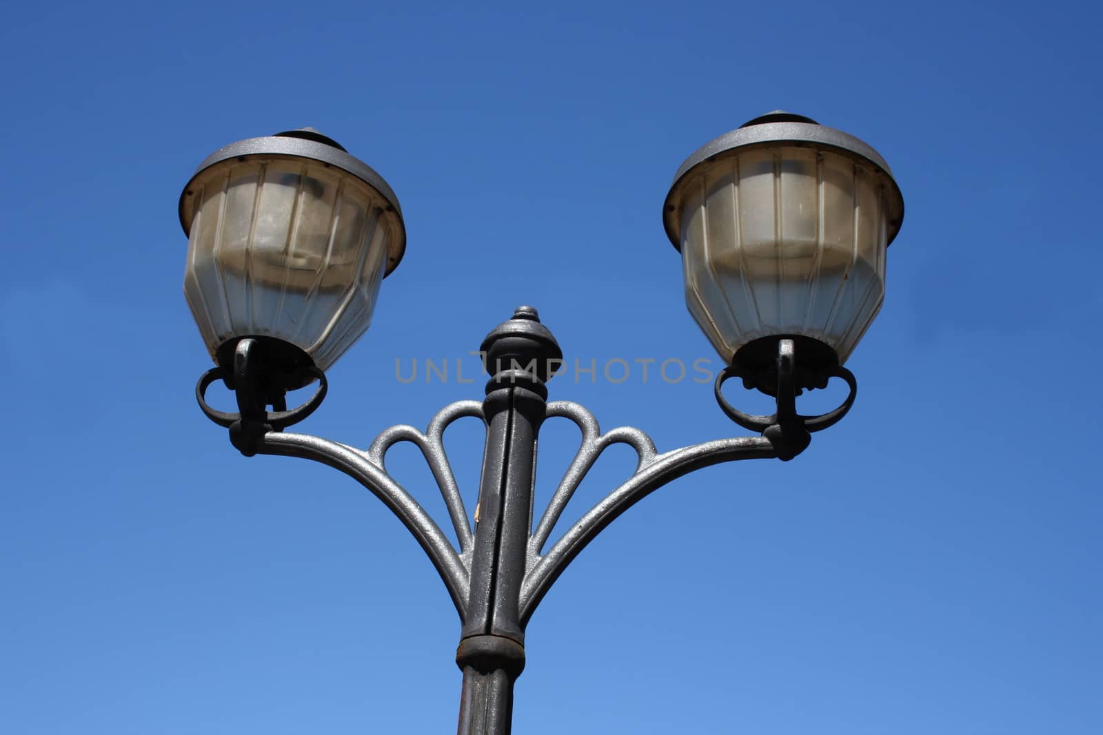 Street light with two lamps, blue sky in the background