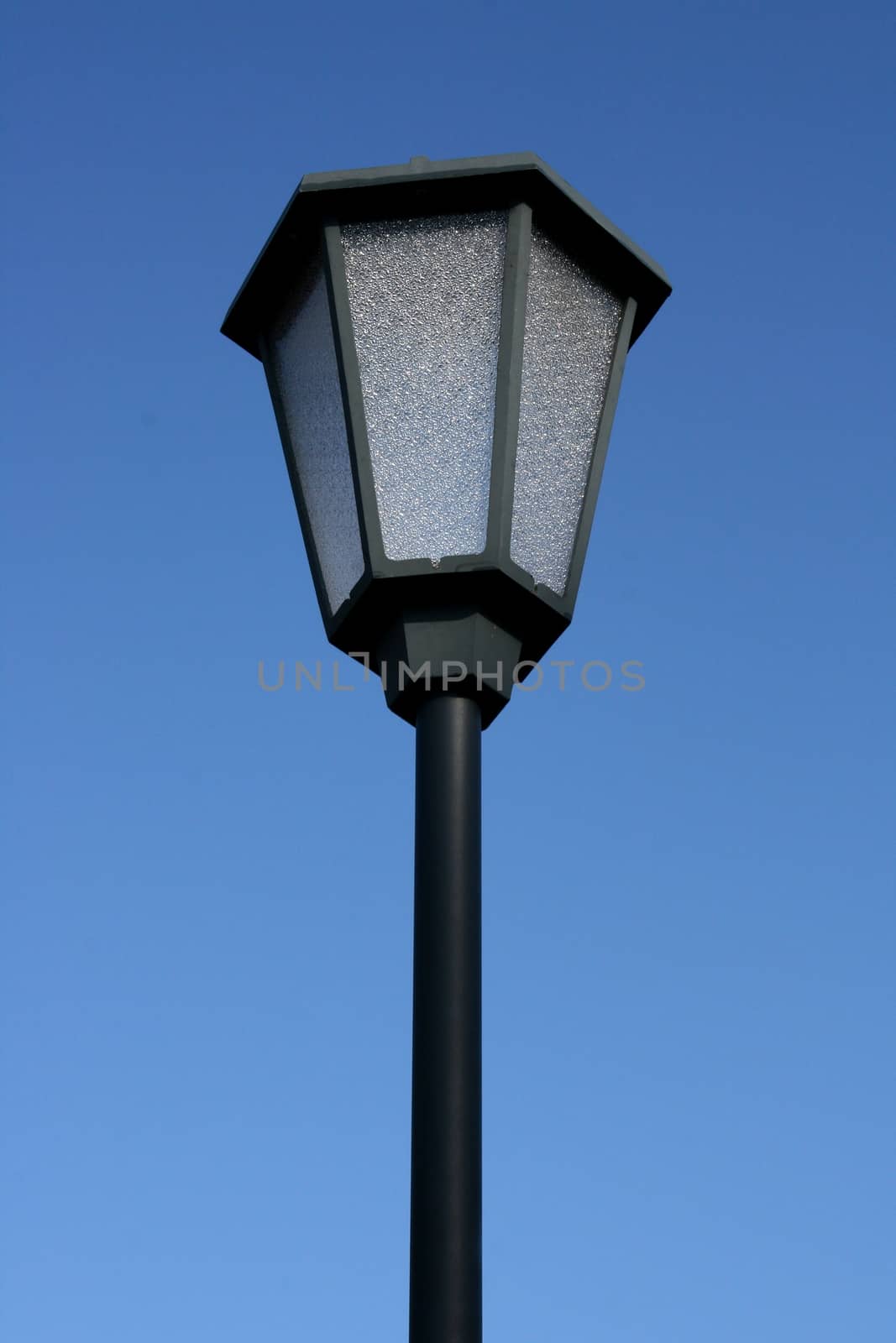 A decorated street lamp, blue sky in the background