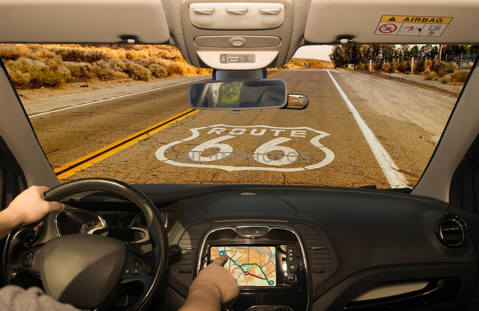 Driving a car while using the touch screen of a GPS navigation system on the Historic Route 66 in California, USA