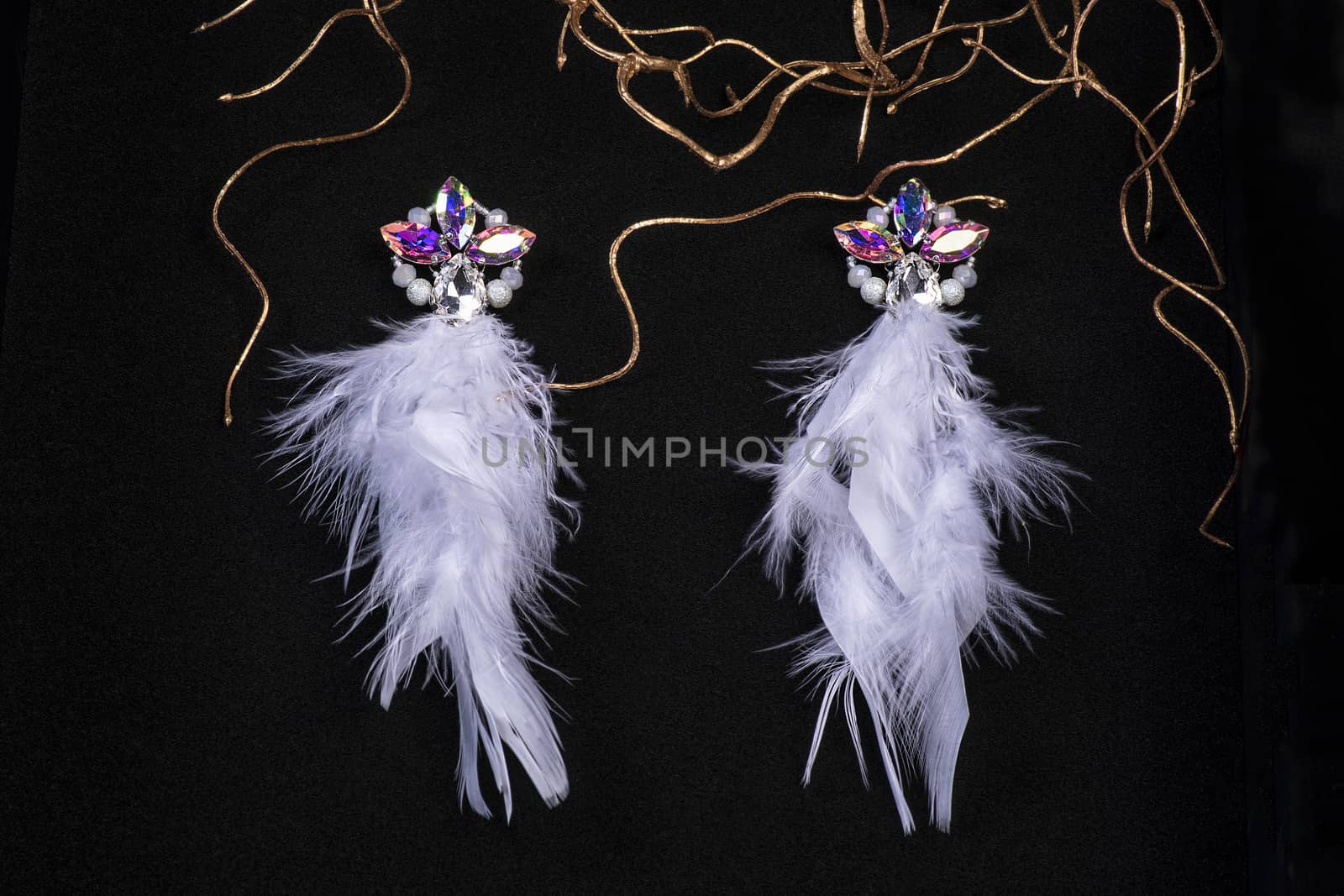 Jewelry. Women's jewelry.Earrings of pink feathers on a black background close-up, selective focus.