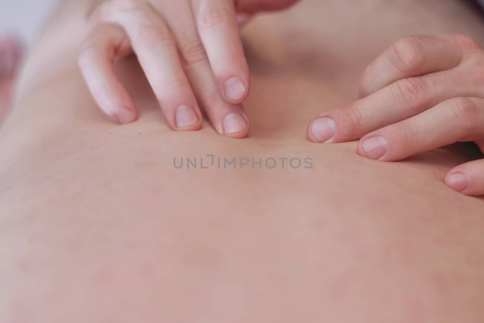 Close up image of physiotherapist massaging .Men's hands make massage. Care for the body. Back pain, back massage.