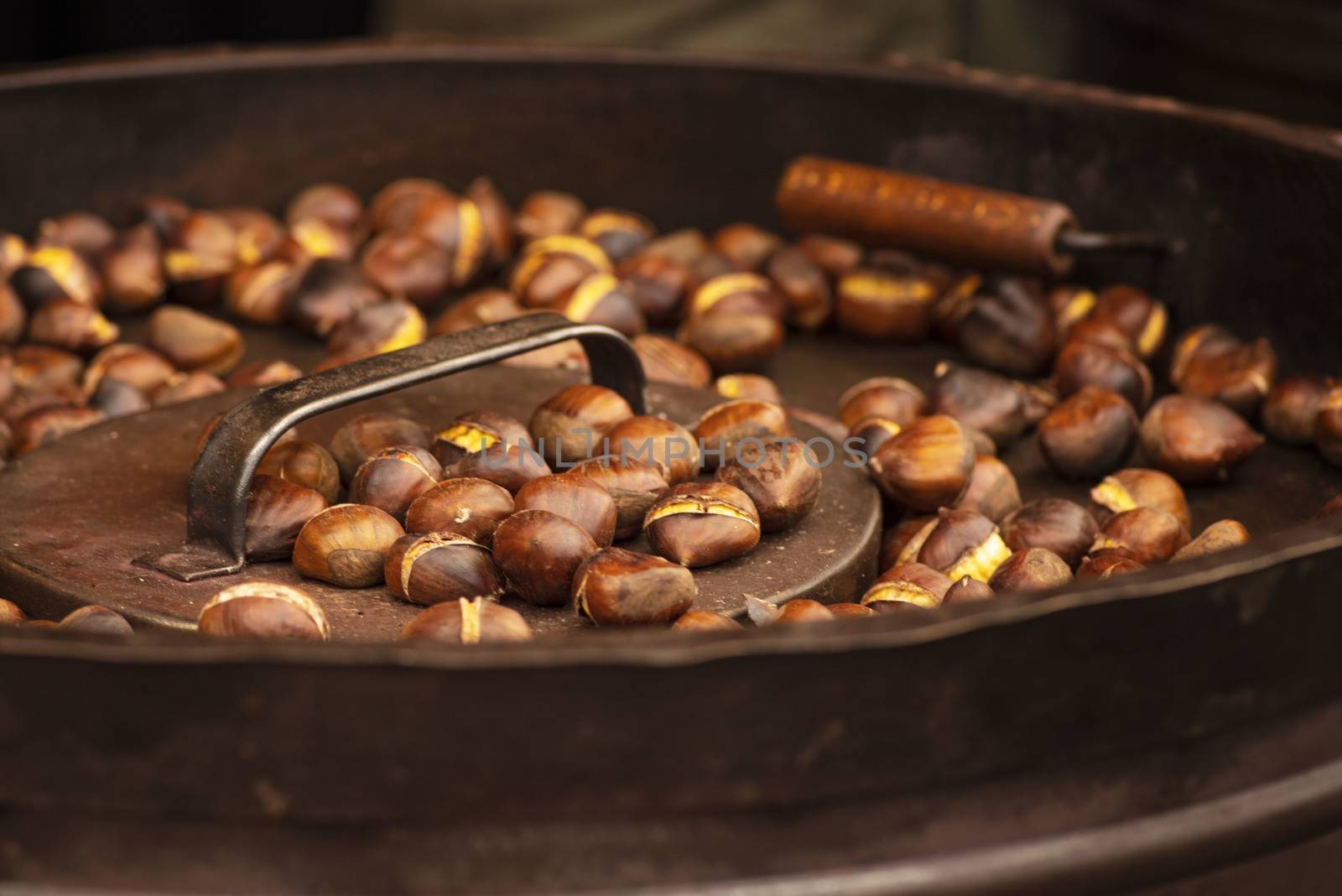 Street food. Roasted chestnuts.Fried chestnuts on the street in a huge bowl.