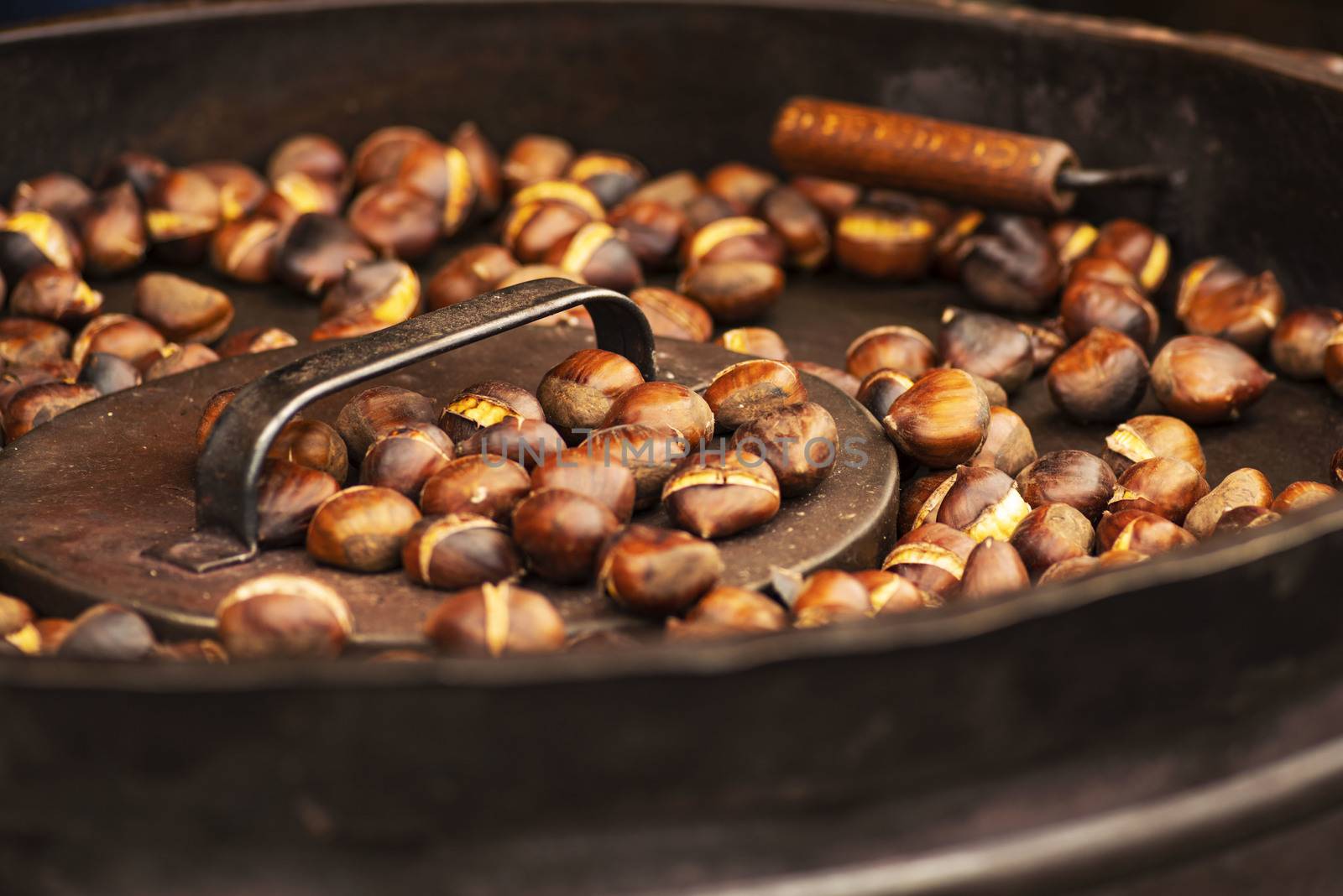 Street food. Roasted chestnuts.Fried chestnuts on the street in a huge bowl.