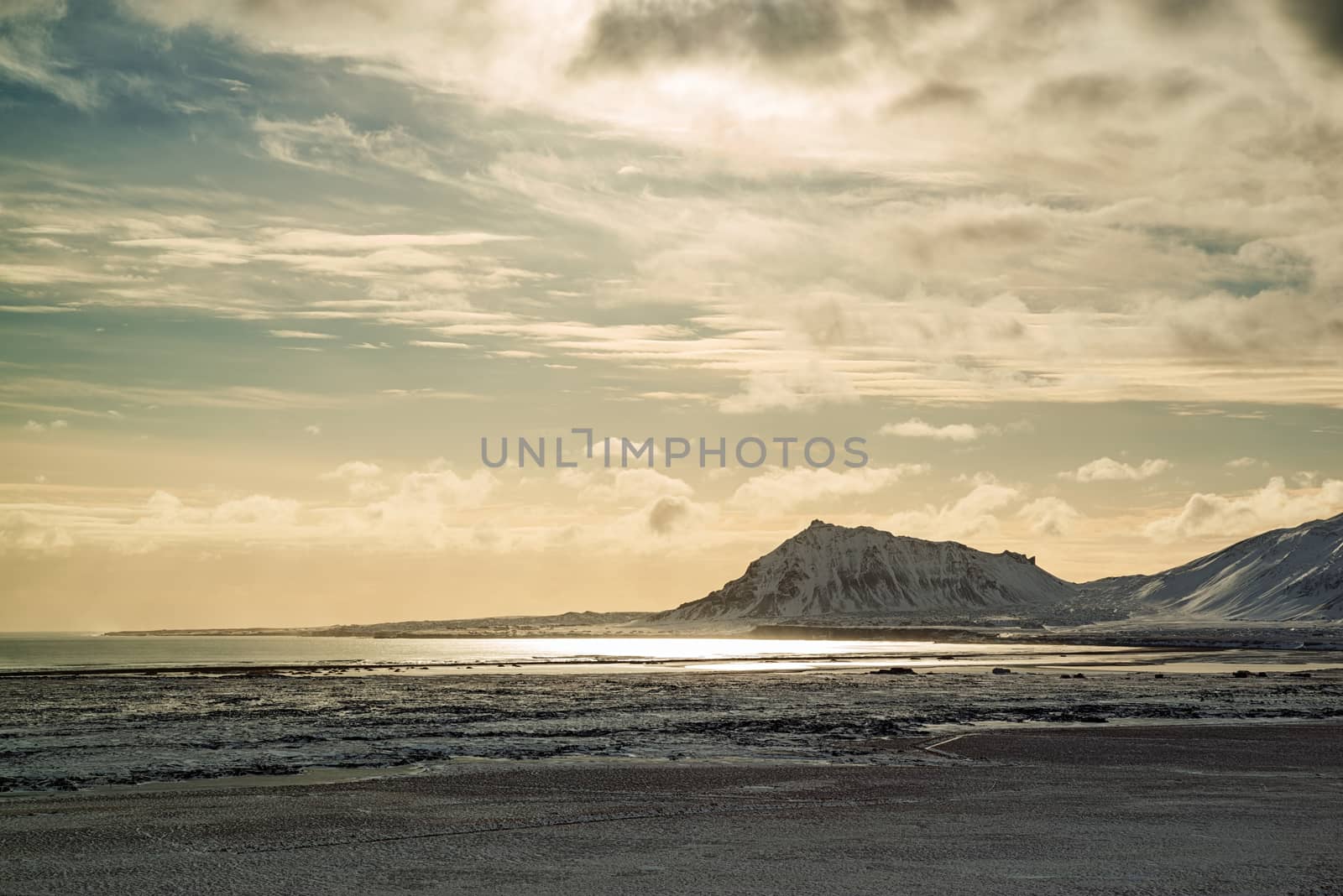 Mountains in Snaefellsnes peninsula with the sun reflected in the water, Iceland