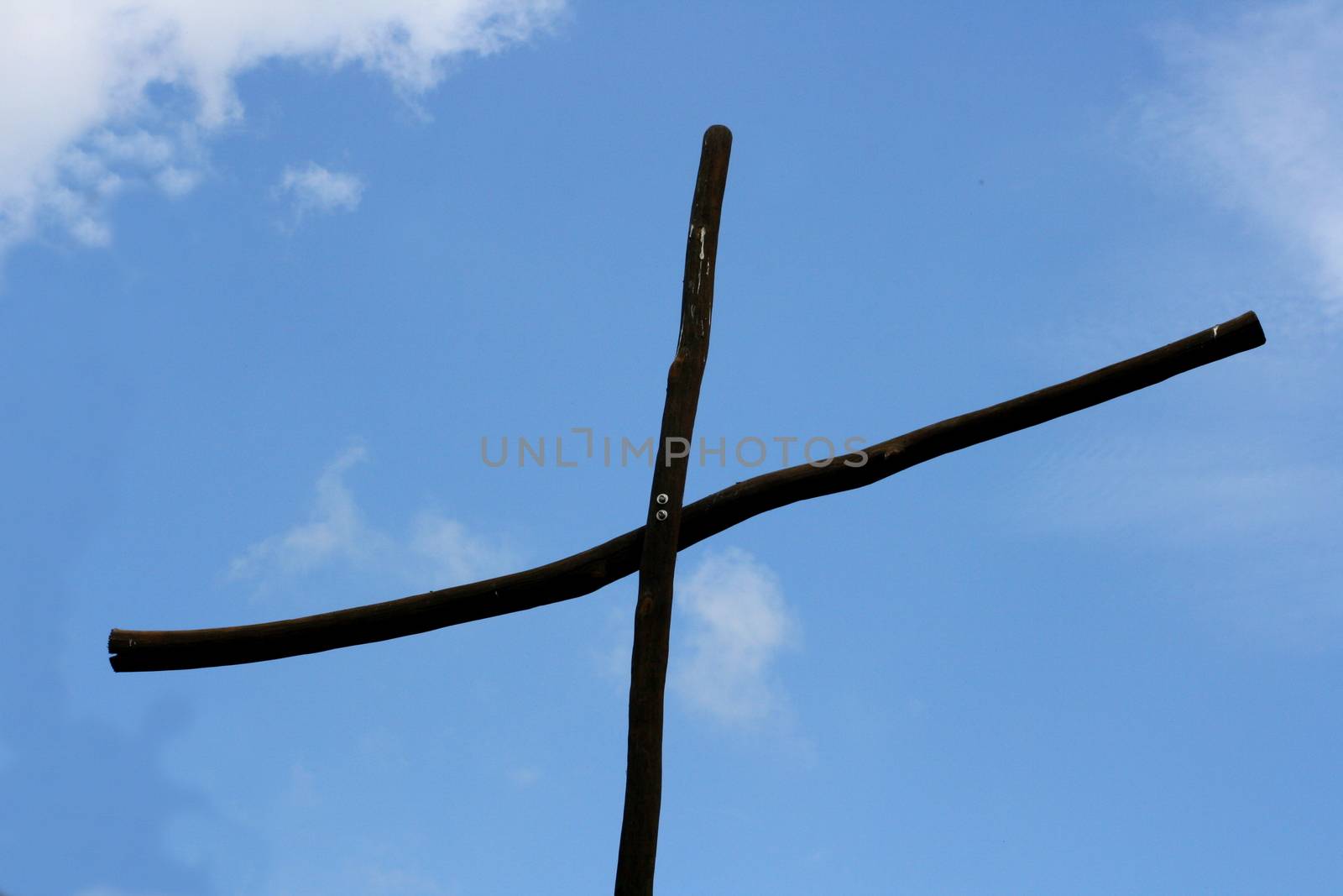 Simple wooden cross with blue sky in the background