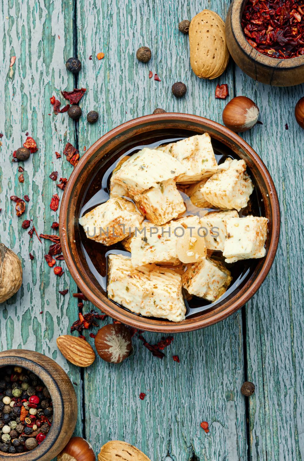 Feta cheese with herbs and garlic on old wooden background