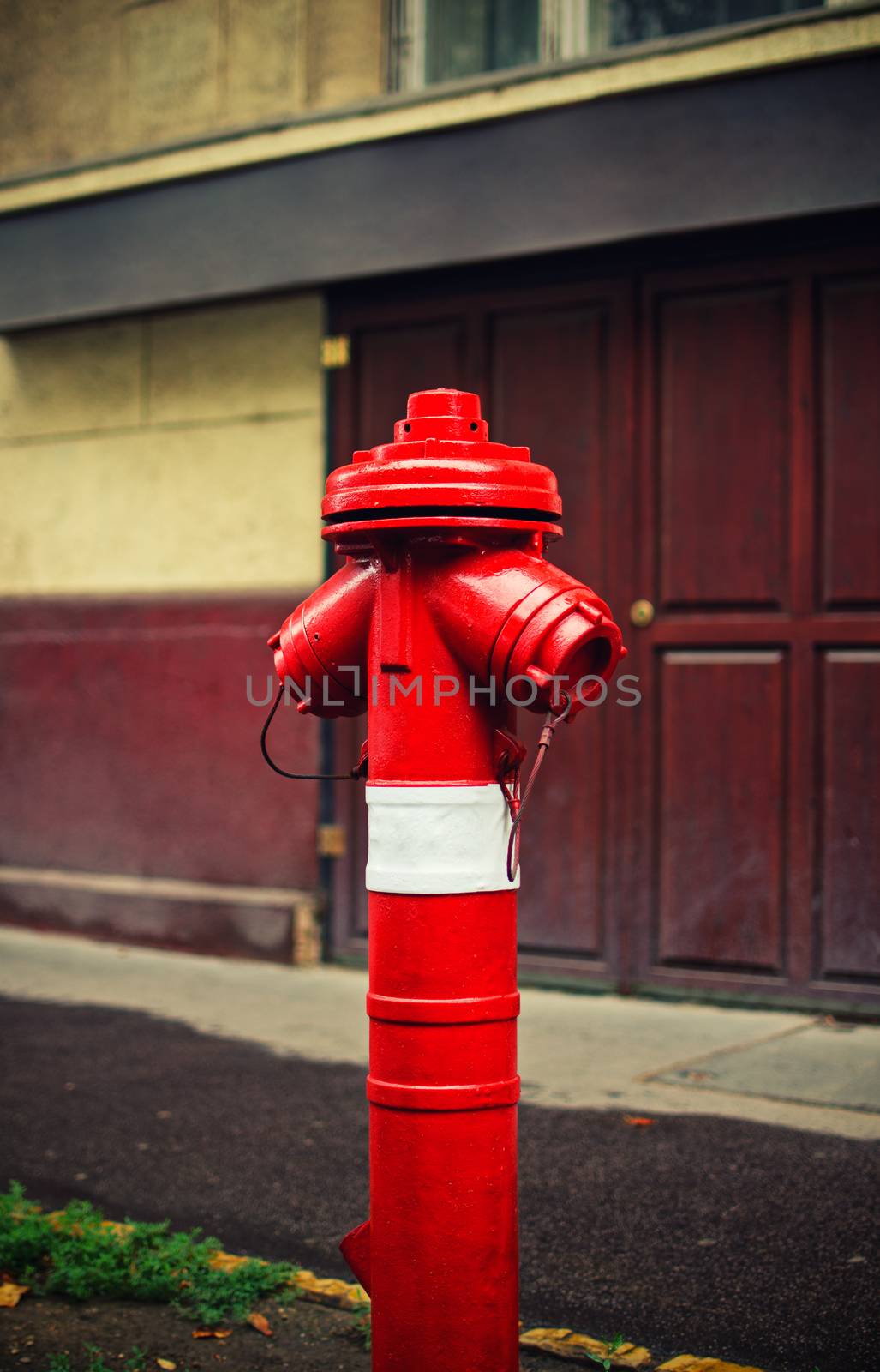 Close up shot of a red fire hydrant on a sidewalk of a street. Fire hydrant for emergency fire access.