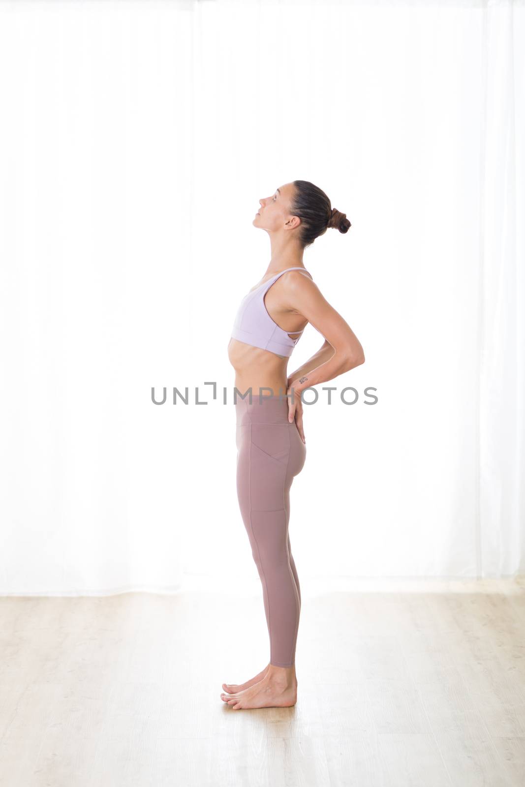 Portrait of gorgeous active sporty young woman practicing yoga in studio. Beautiful girl practice Ardha Chandrasana,half moon yoga pose. Healthy active lifestyle, working out in gym by kasto