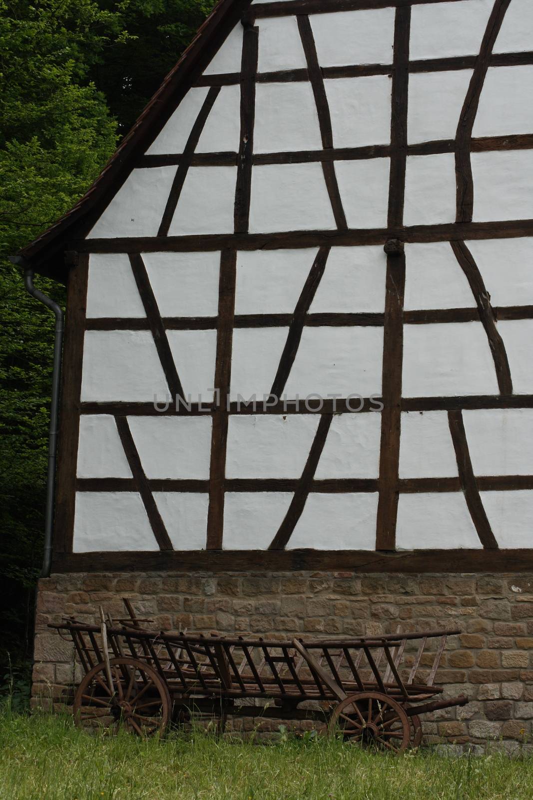 A historical cart parked before a half-timbered House