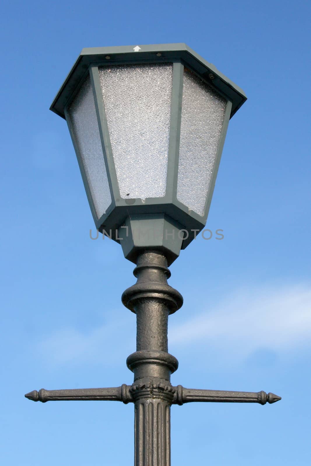 A decorated street lamp, blue sky in the background