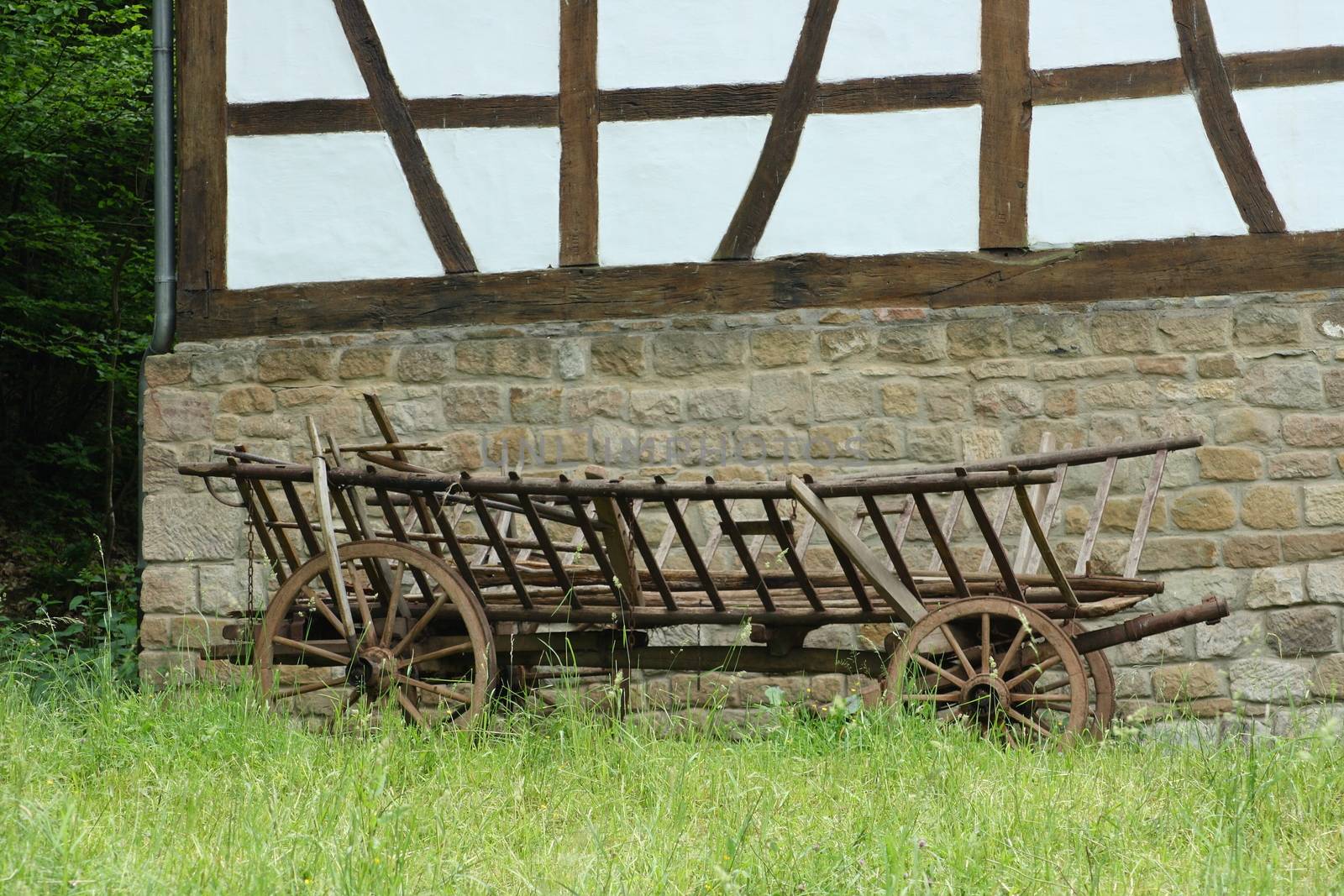 A historical cart parked before a half-timbered House