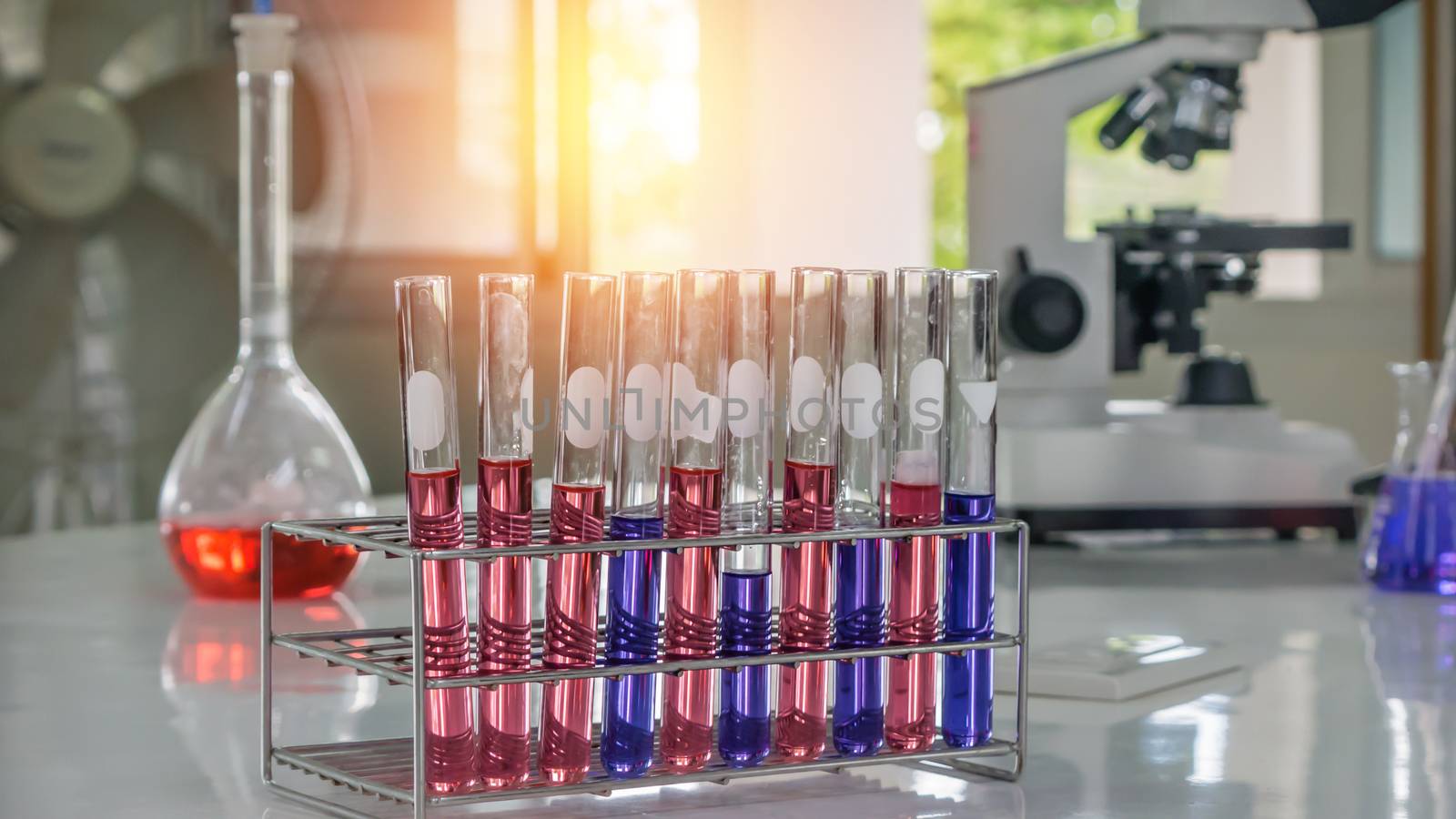 Different laboratory test tubes with colored liquid and with reflection