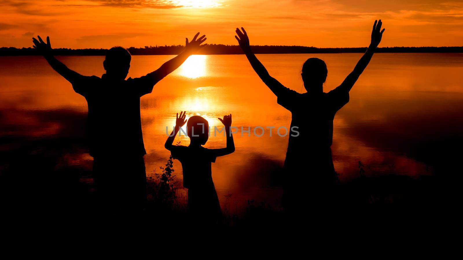 Happy family standing  on the dawn time . sunset in nature