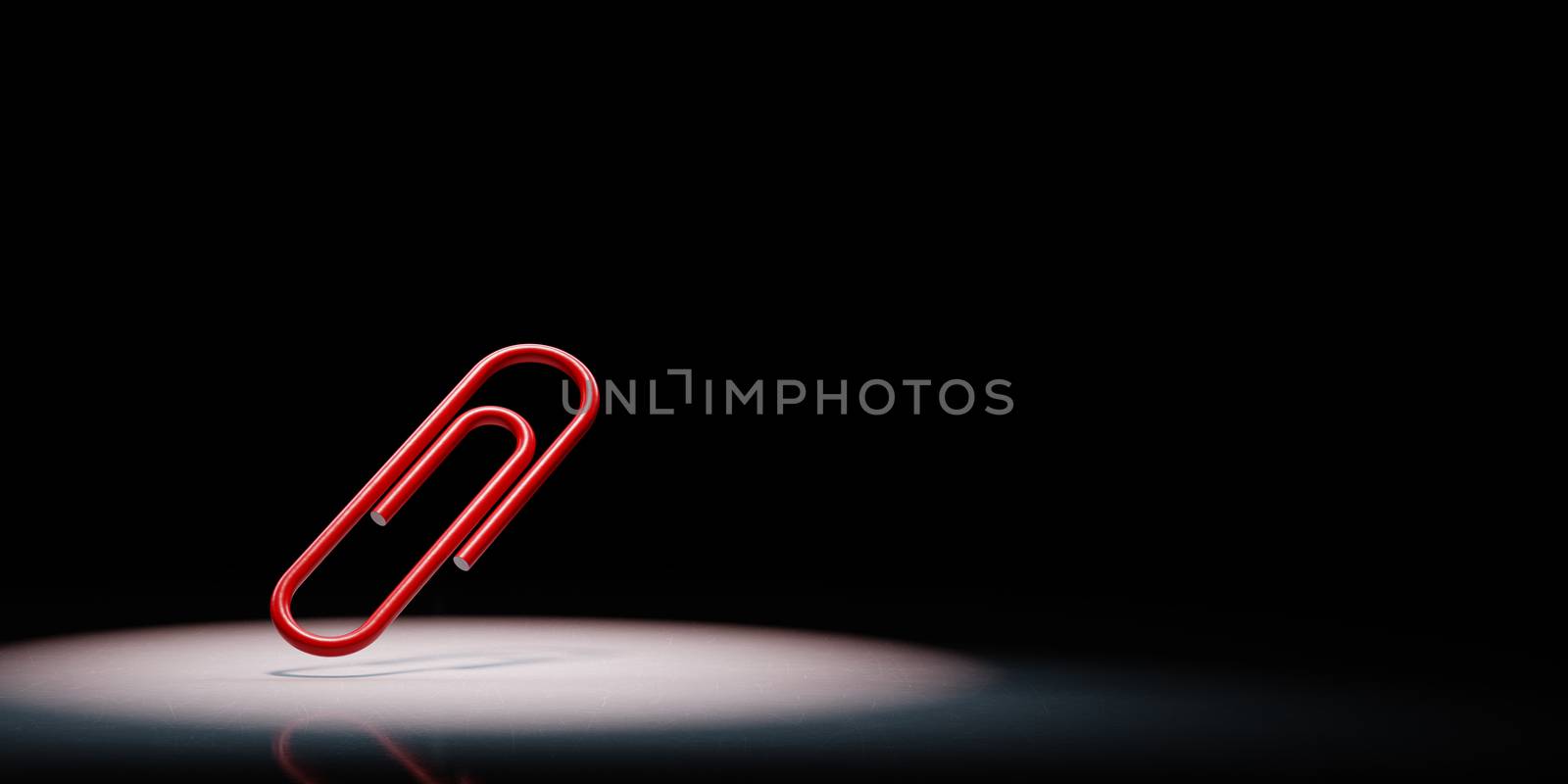 One Red Paperclip Spotlighted on Black Background by make