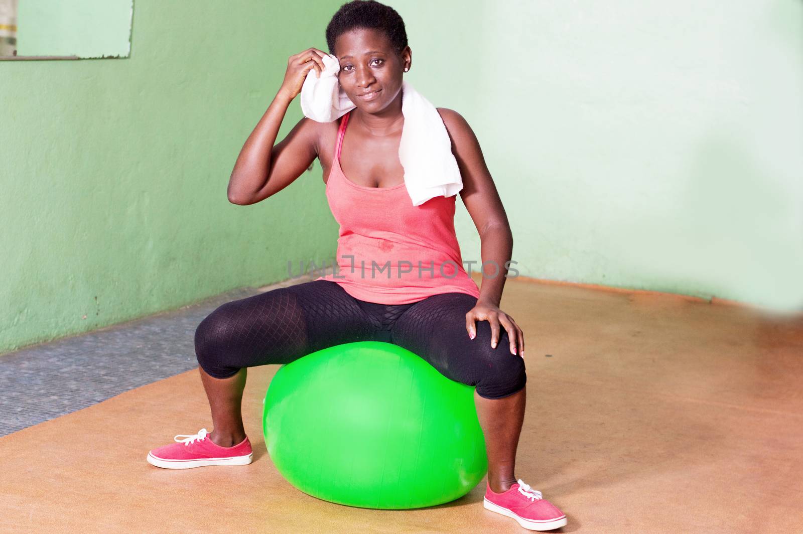 Young woman sitting on a ball for fitness.