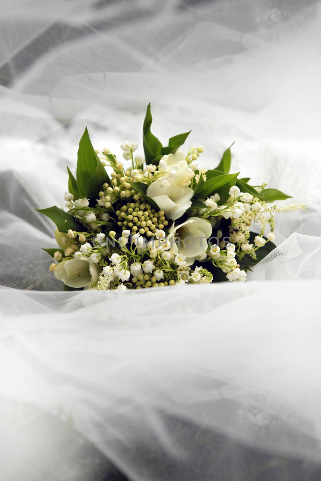 Wedding bouquet on a background of a veil