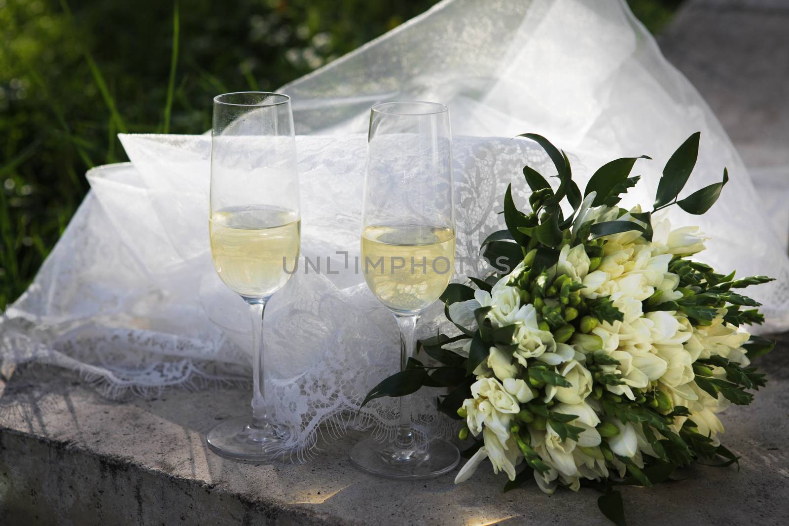 Two glasses of champagne and bridal bouquet by friday