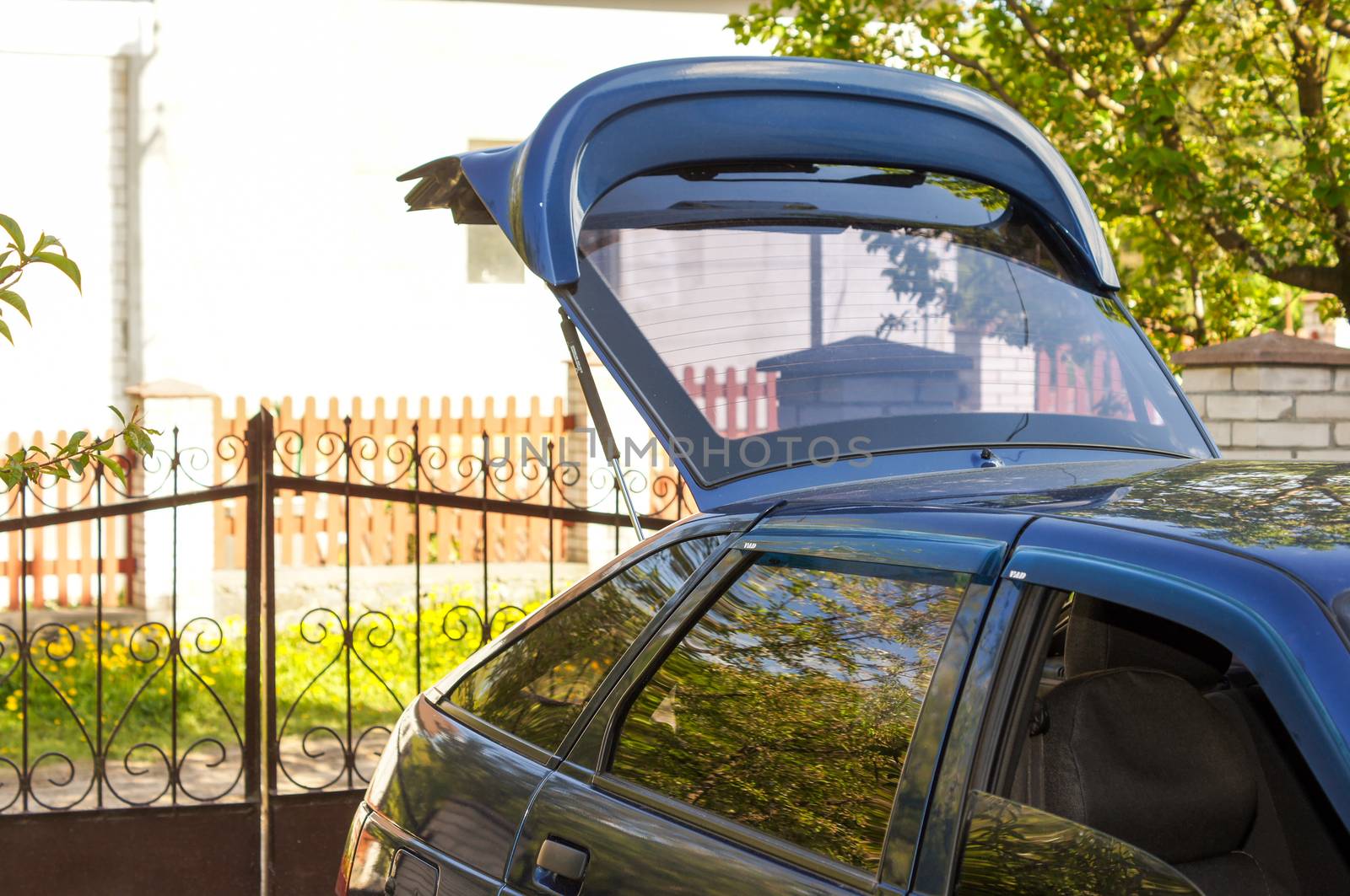 Black Car in the country with an open luggage compartment by Adamchuk