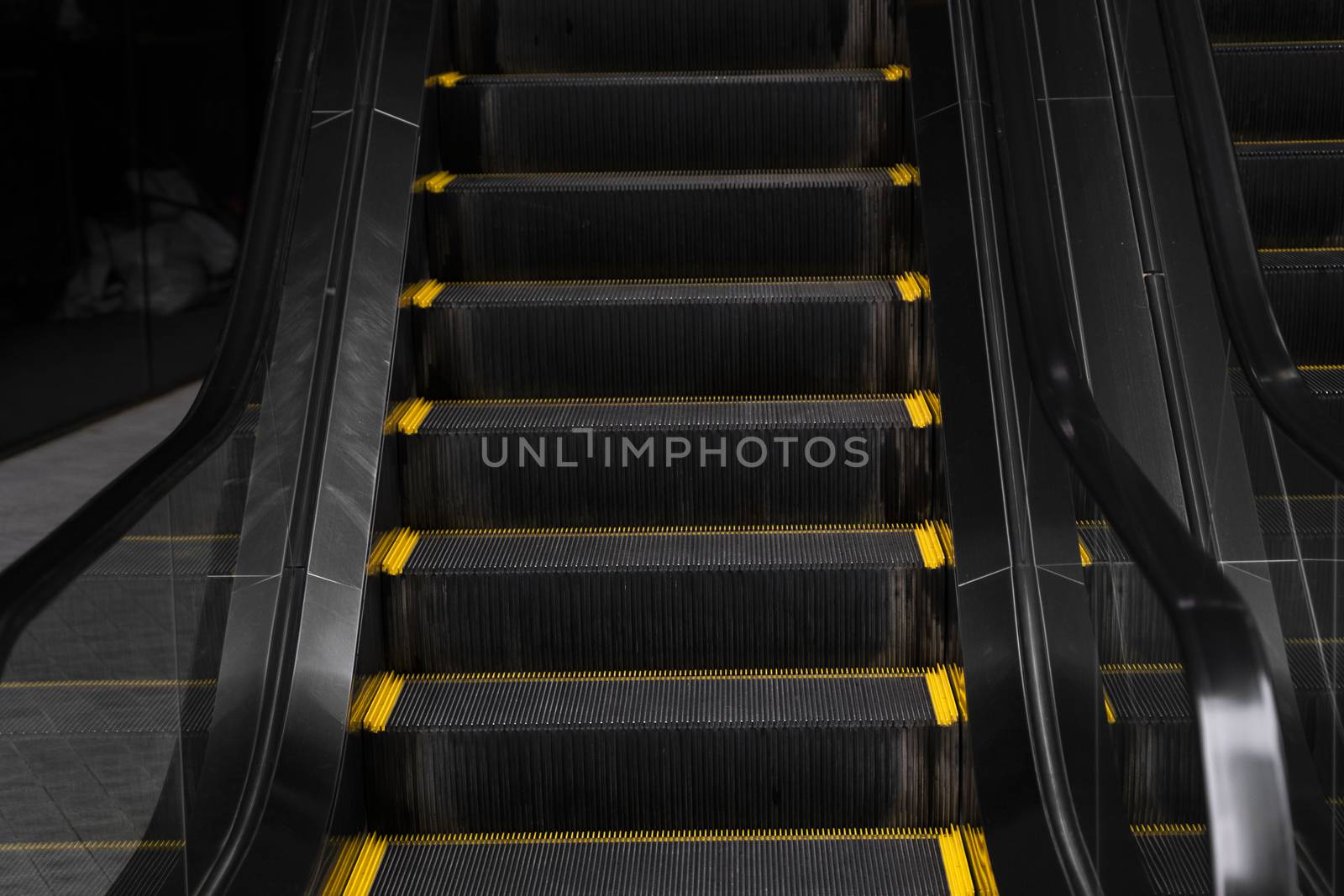 Empty escalators stairway with a yellow stripes