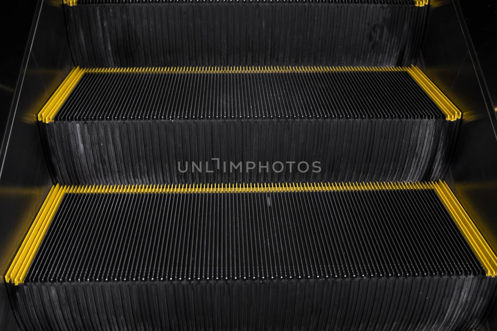 Empty escalators stairway with a yellow stripes